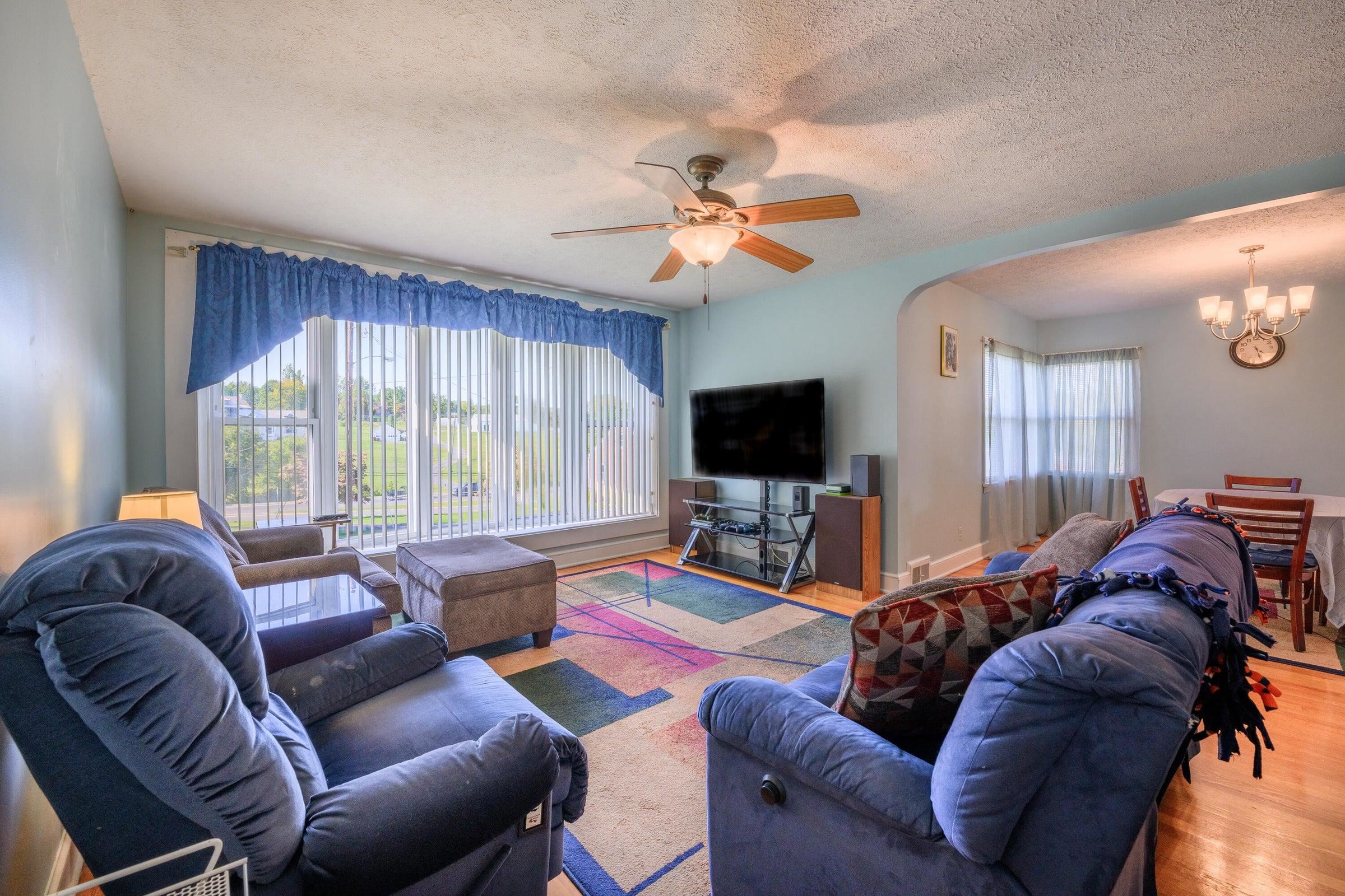 The bank of windows bring light into the living room.