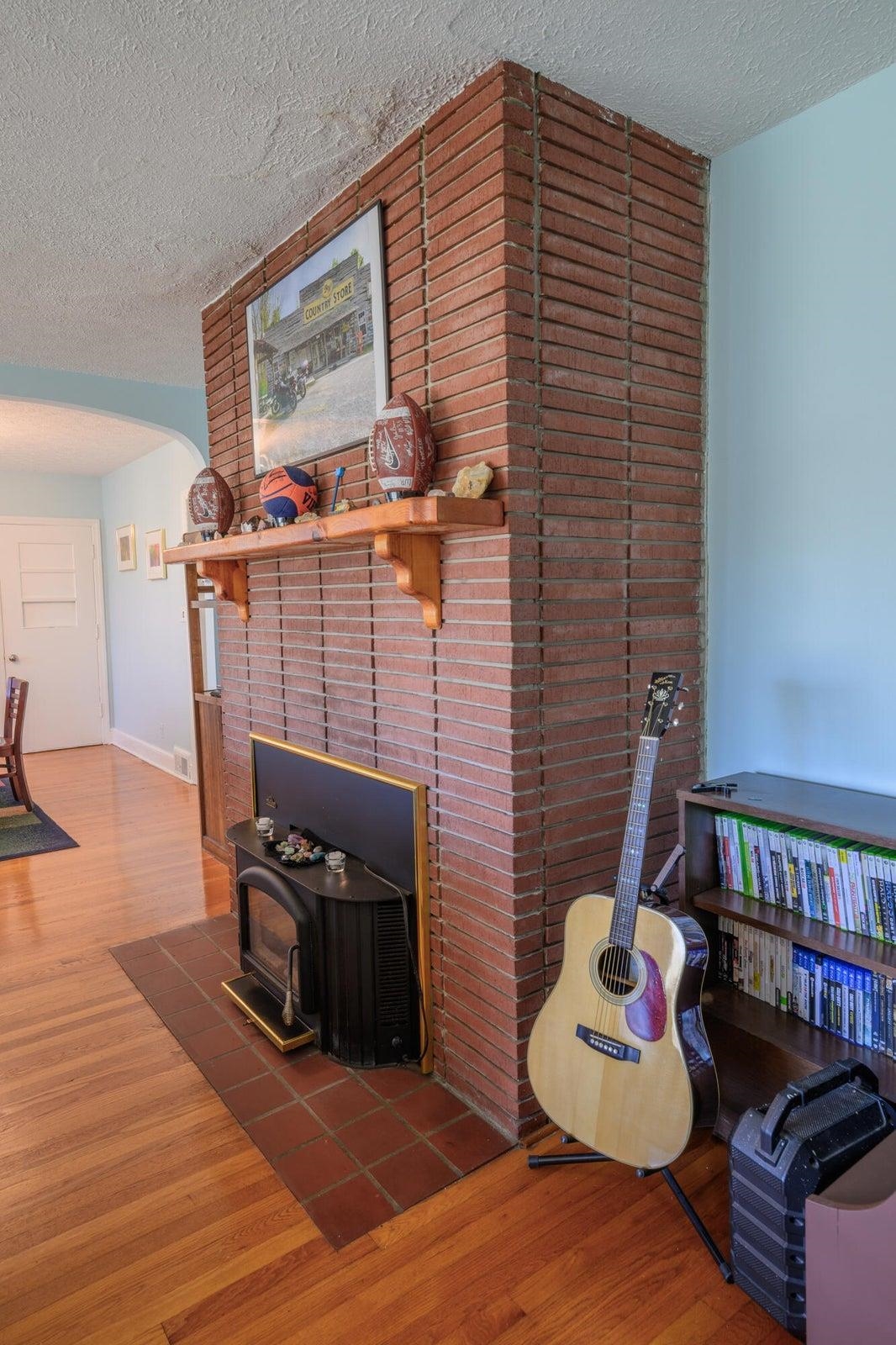 The living room features a brick fire place with a wood stove insert.