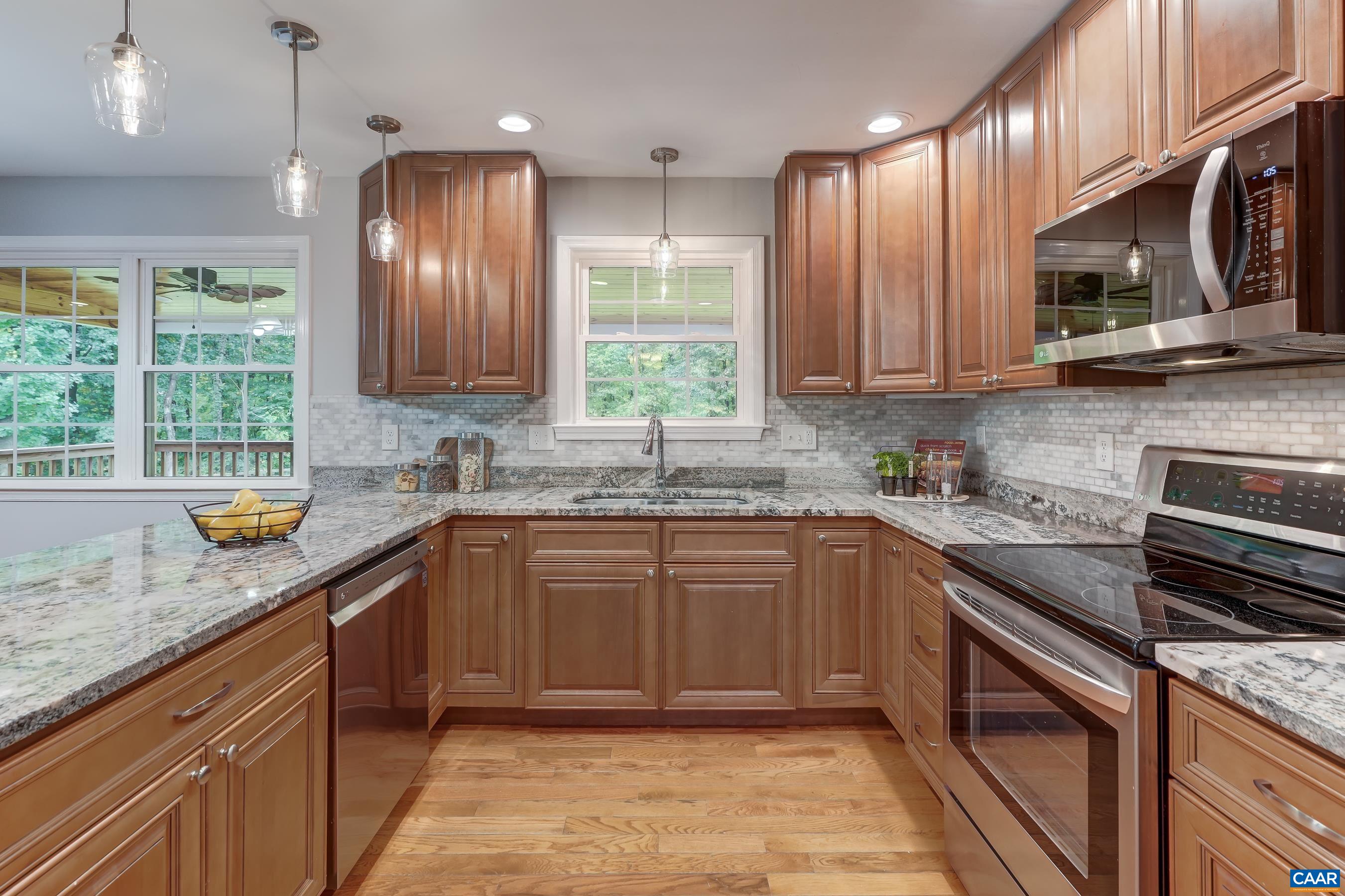 Stainless steel appliances and tile backsplash in kitchen.