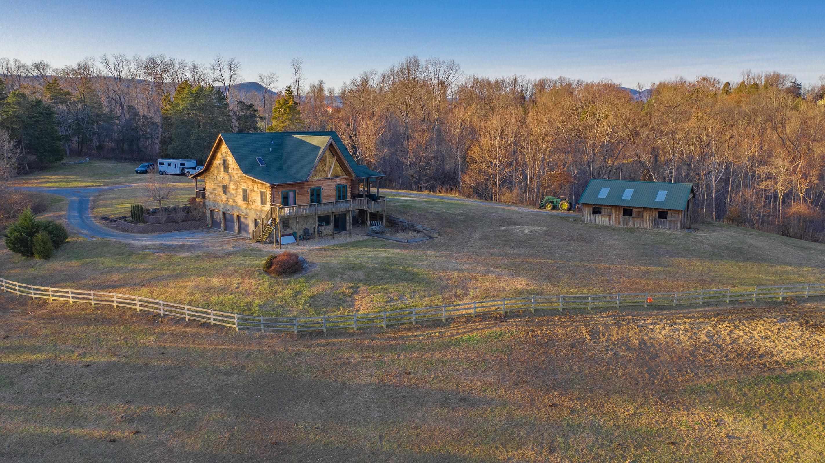 Rear view of house, 36' X 34' barn and fenced field. Three bay garage on left side . . . includes mud room and workshop.