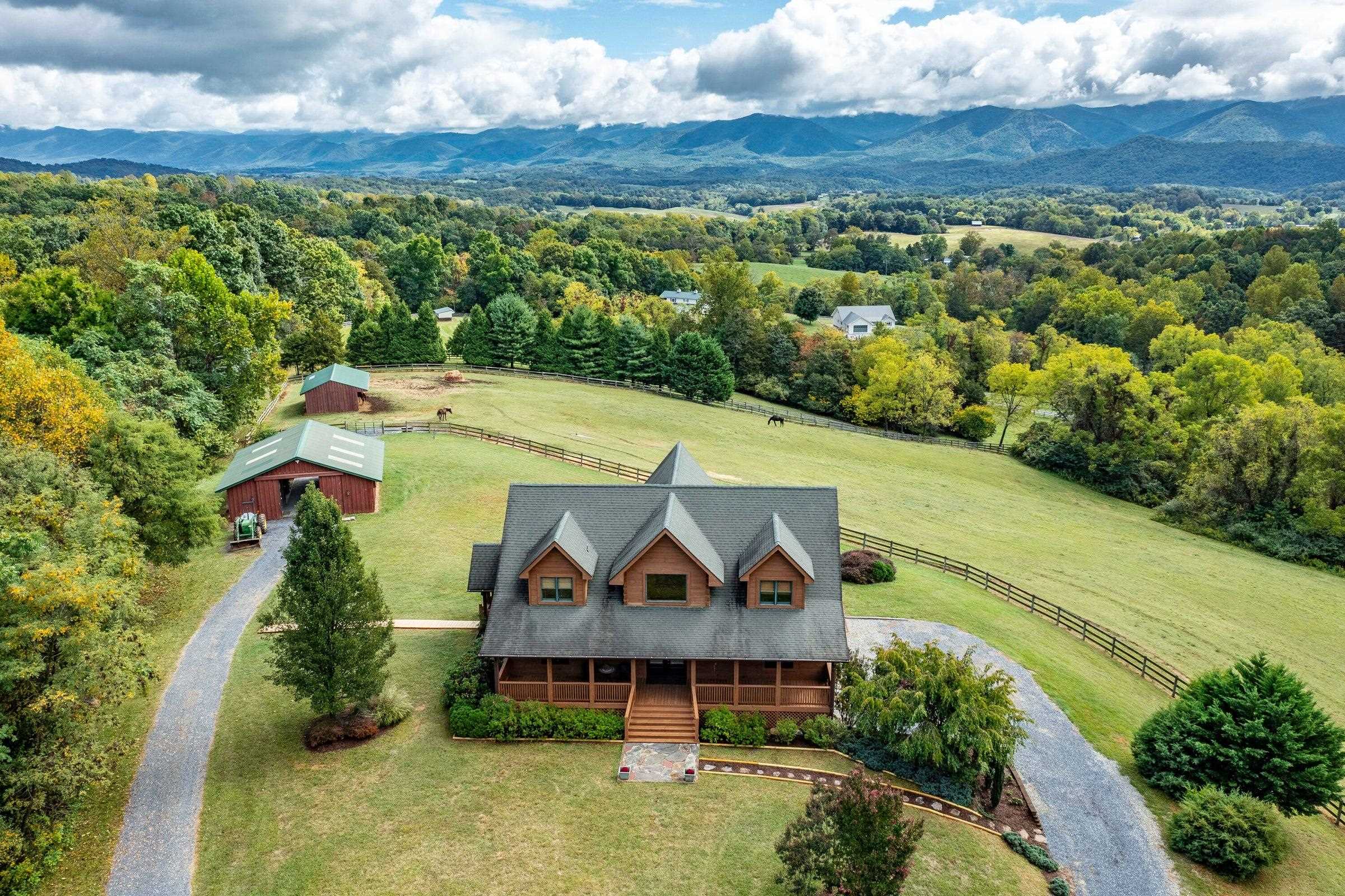 Ariel view of exquisite log home, horse barn, run-in shed, well-maintained board fencing