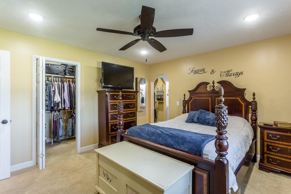 view of walk-in closet and access to full bath.