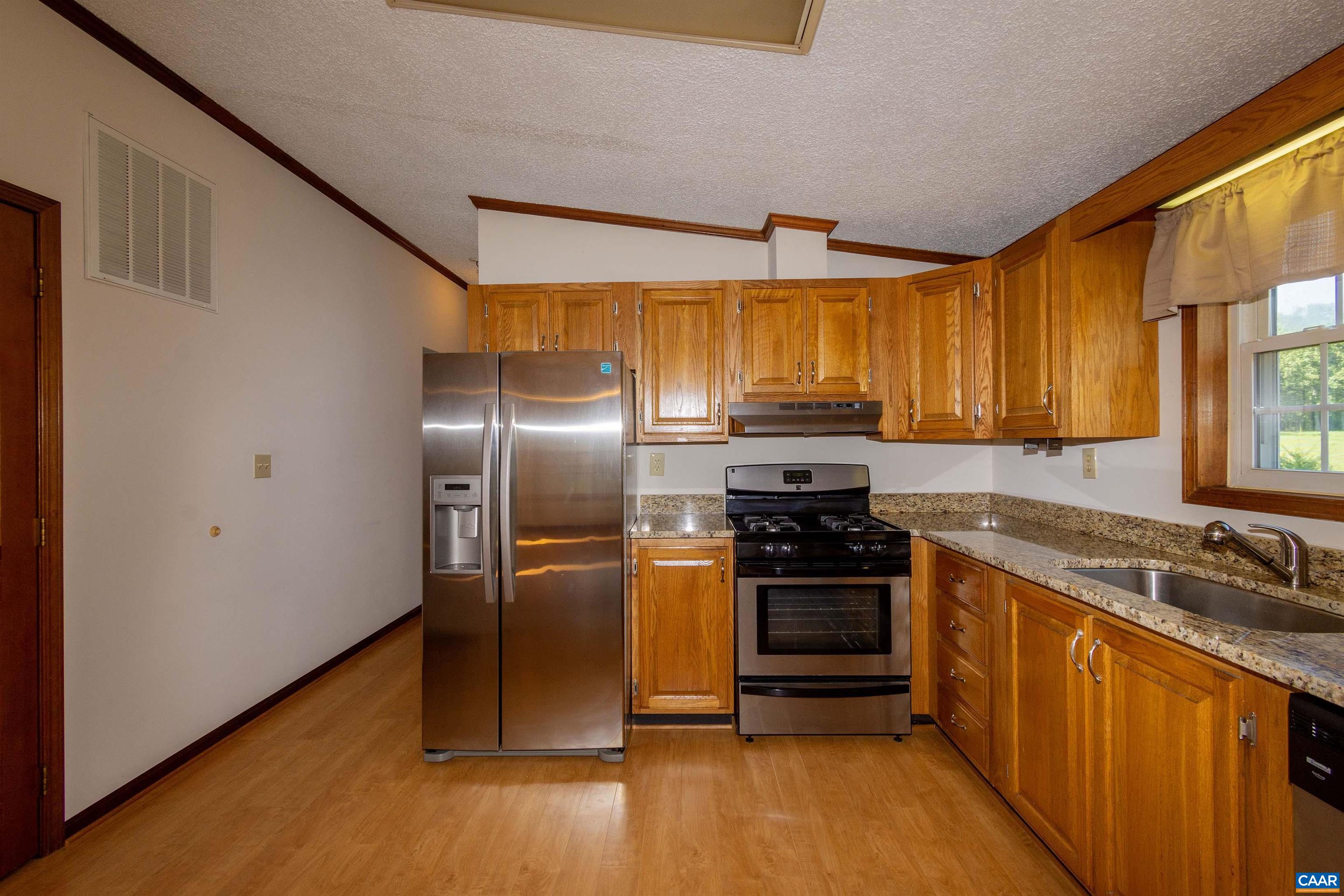 with oak cabinets and stainless steel appliances.