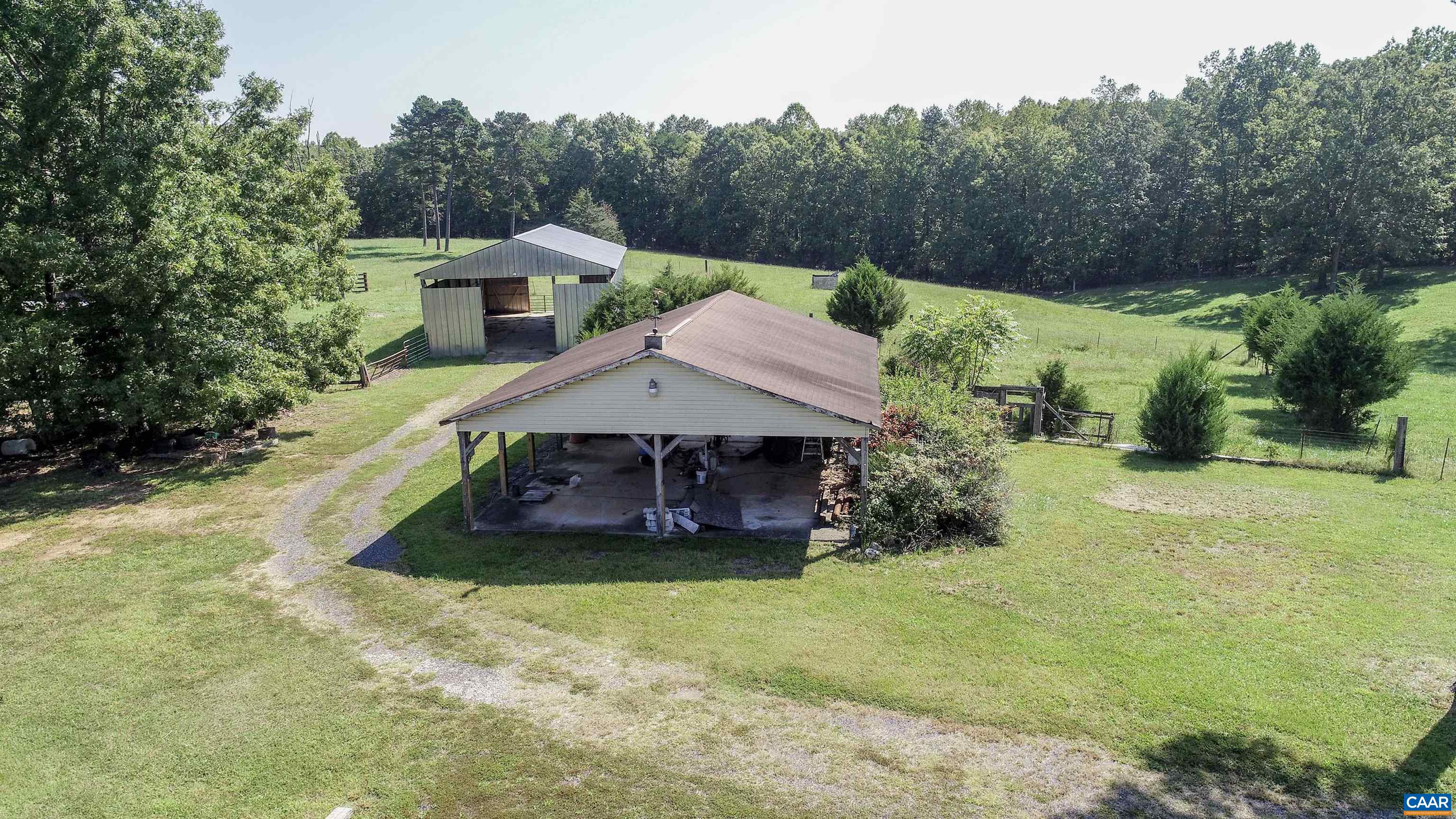 1280 square foot structure in the foreground, with hay barn behind. Carport has its own washroom with a door and a dedicated well providing water.