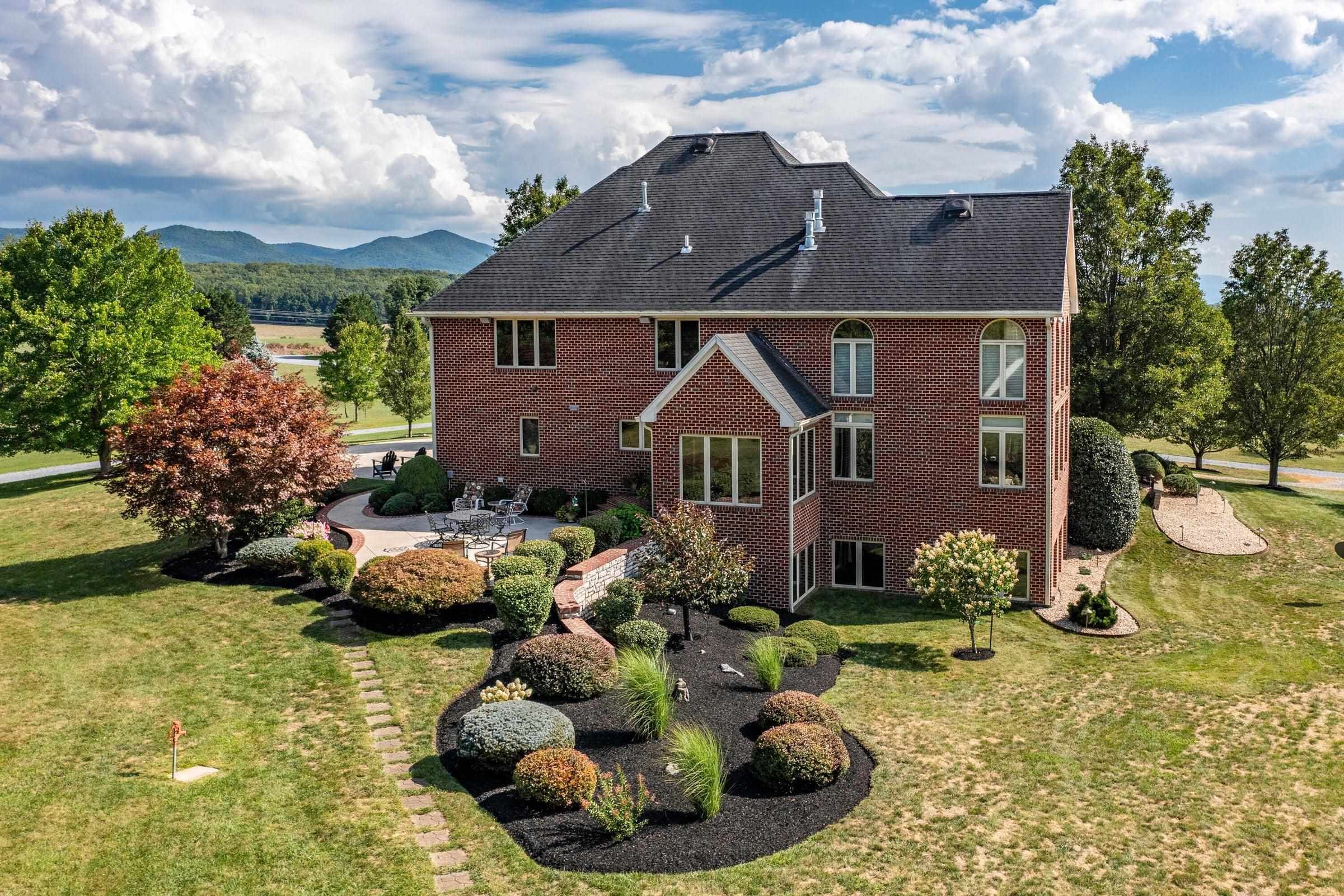 Beautifully landscaped back lawns of the home. Blue Ridge Mtns in the distance.