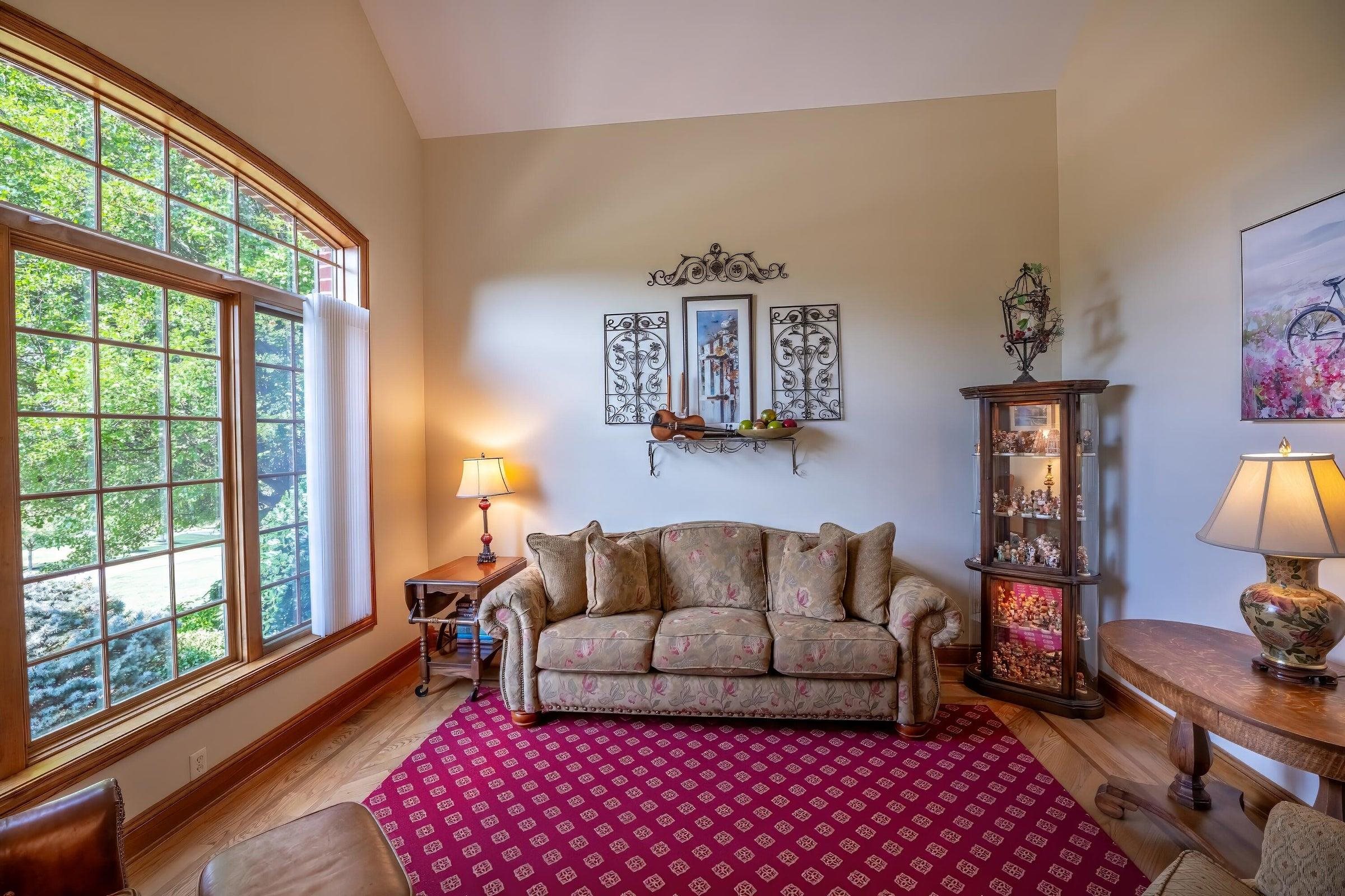 Expansive windows bring nature in to join you as you relax in the front parlor.