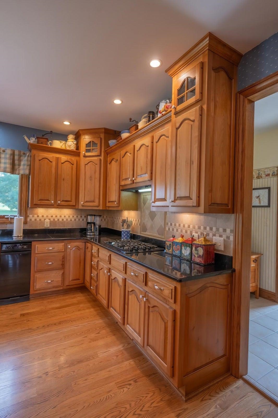 Gas stove top. Custom red birch cabinets. Oak floors.