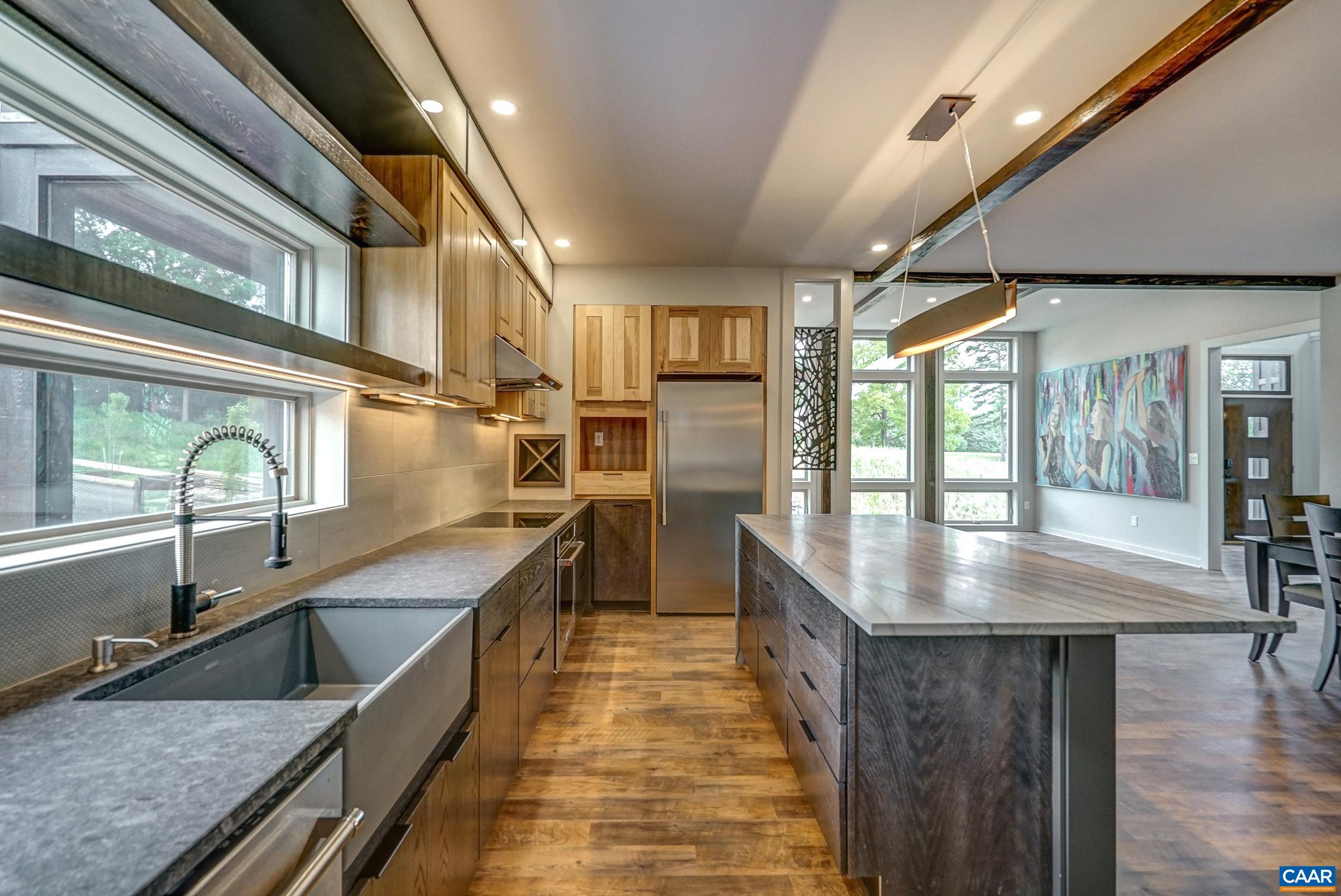 Honed granite surround countertops provide a stunning contrast to gleaming quartz island.