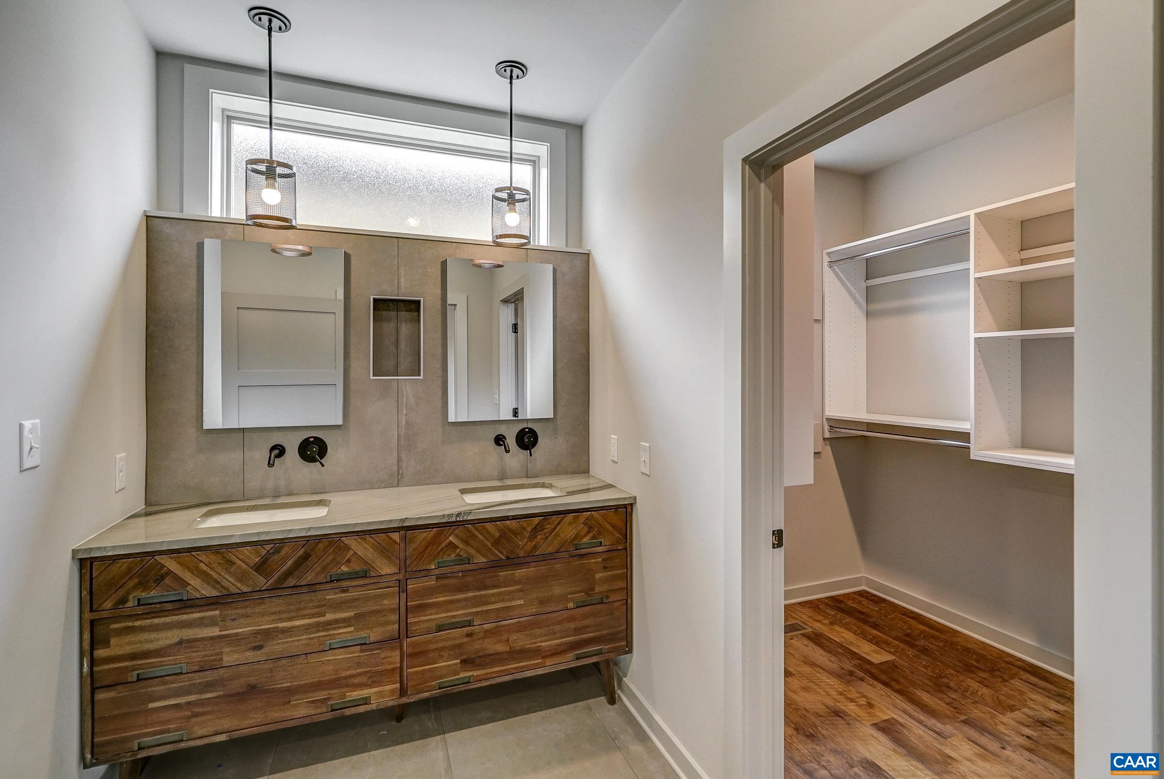 Primary bathroom features floating double sink vanity and heated tile flooring.