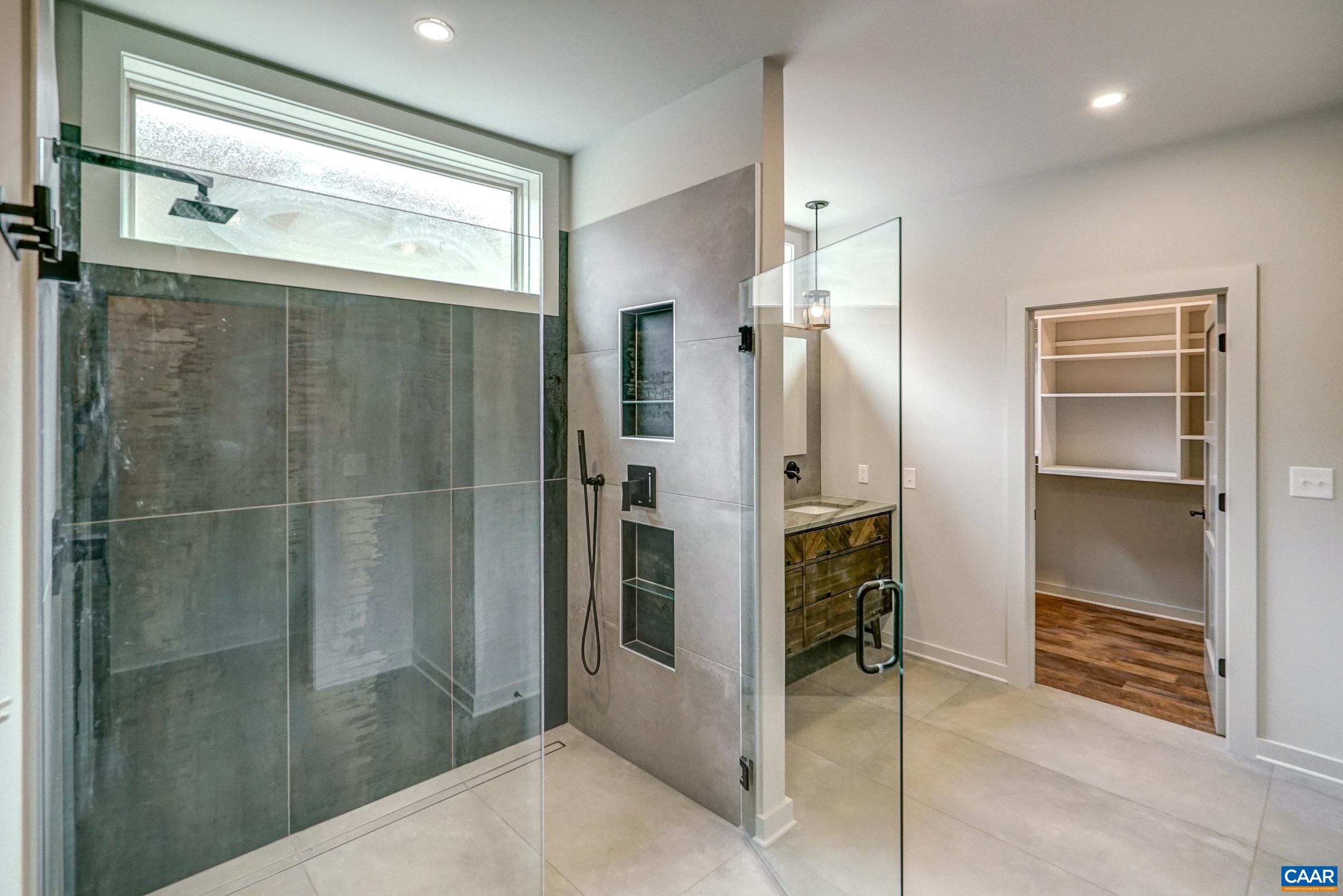 Frameless glass walk-in shower with beautiful tile.