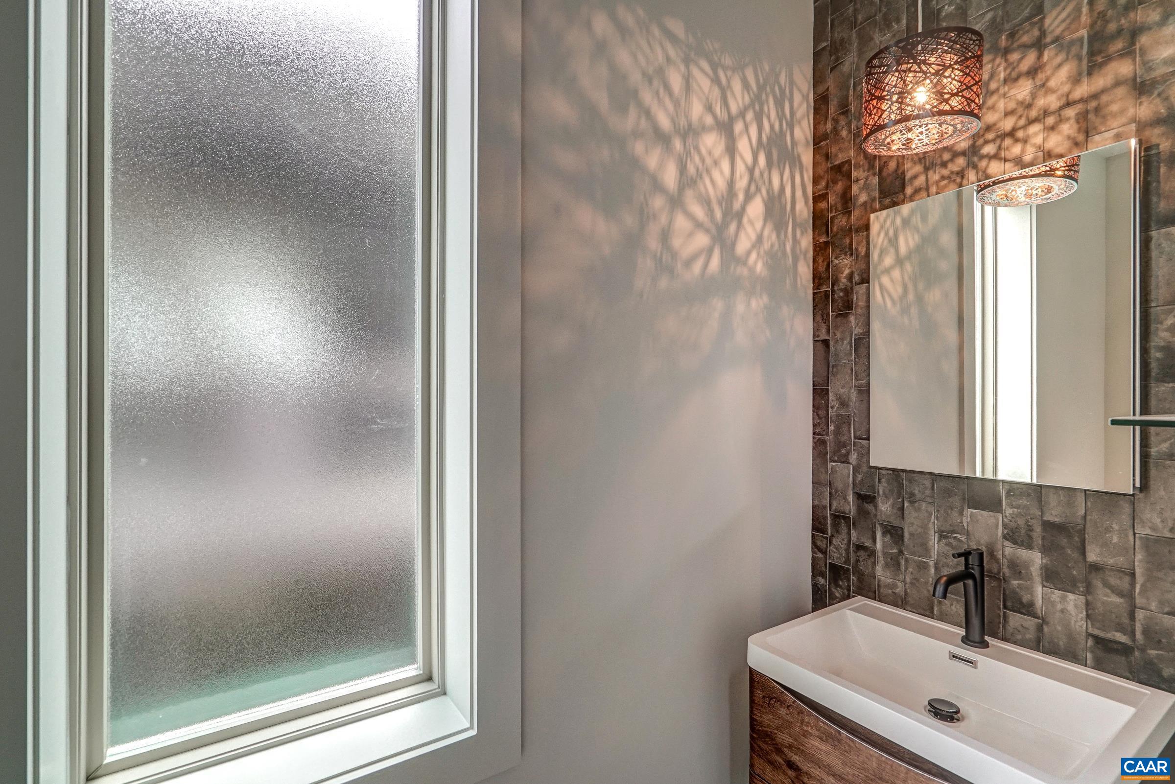 Main floor powder room with frosted glass window, and stunning light fixture.