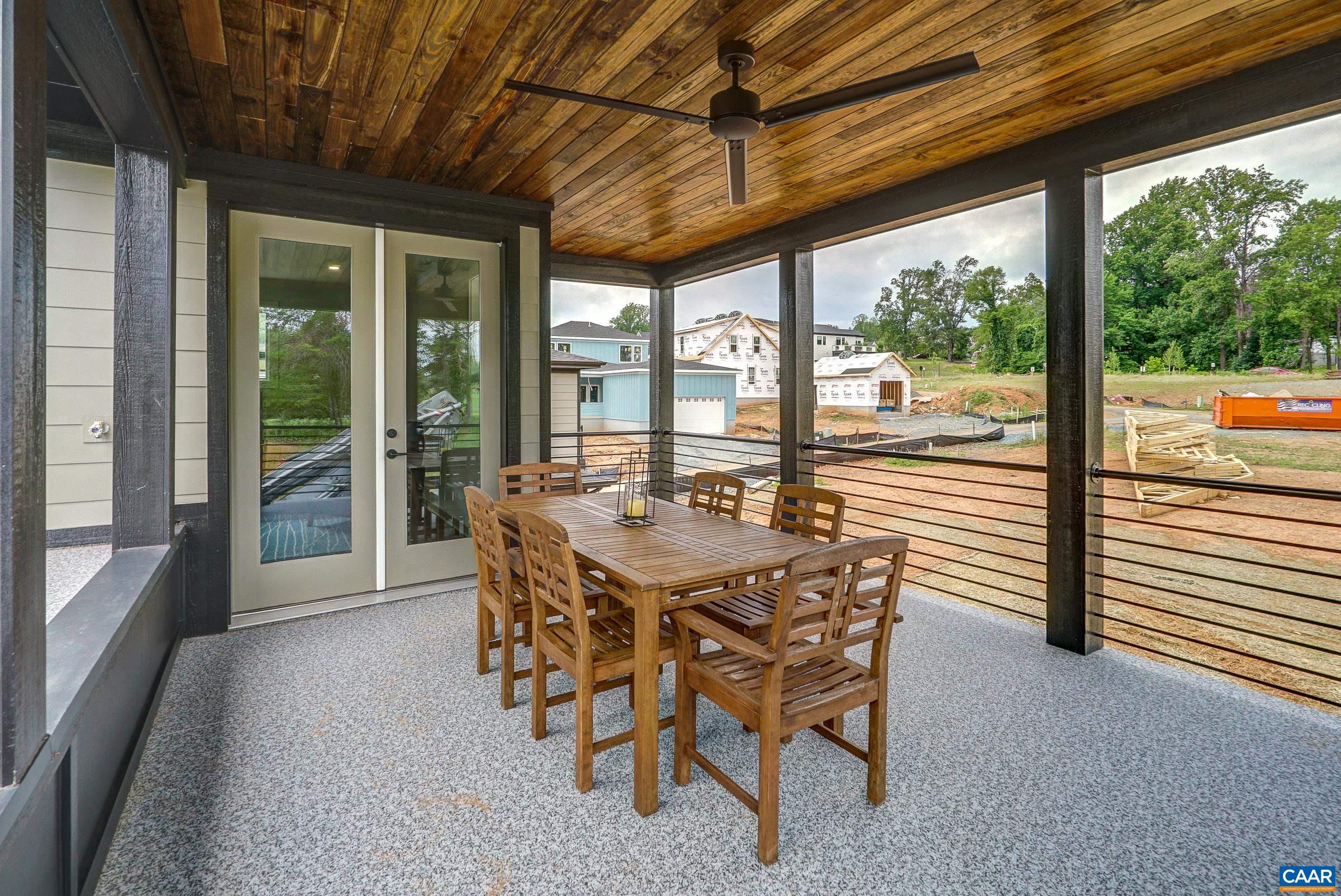 Covered rooftop deck on second level features beadboard ceiling and fan.