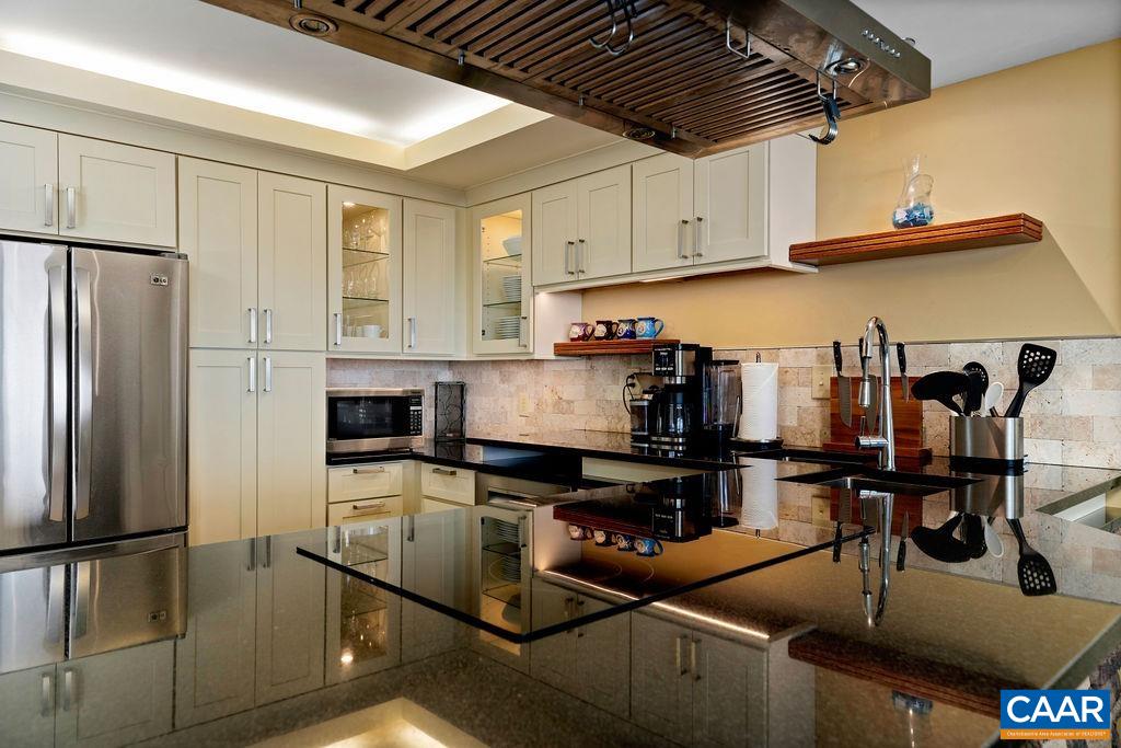 The kitchen has been expanded from the original floor plan and it offers custom cabinets with maple face frames, elevated granite counter tops, Bosch dishwasher, induction cooktop.