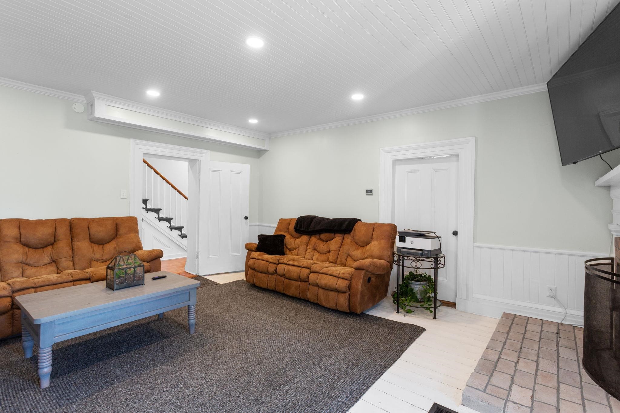 or family room on main level with old fireplace and TV mount on west wall.