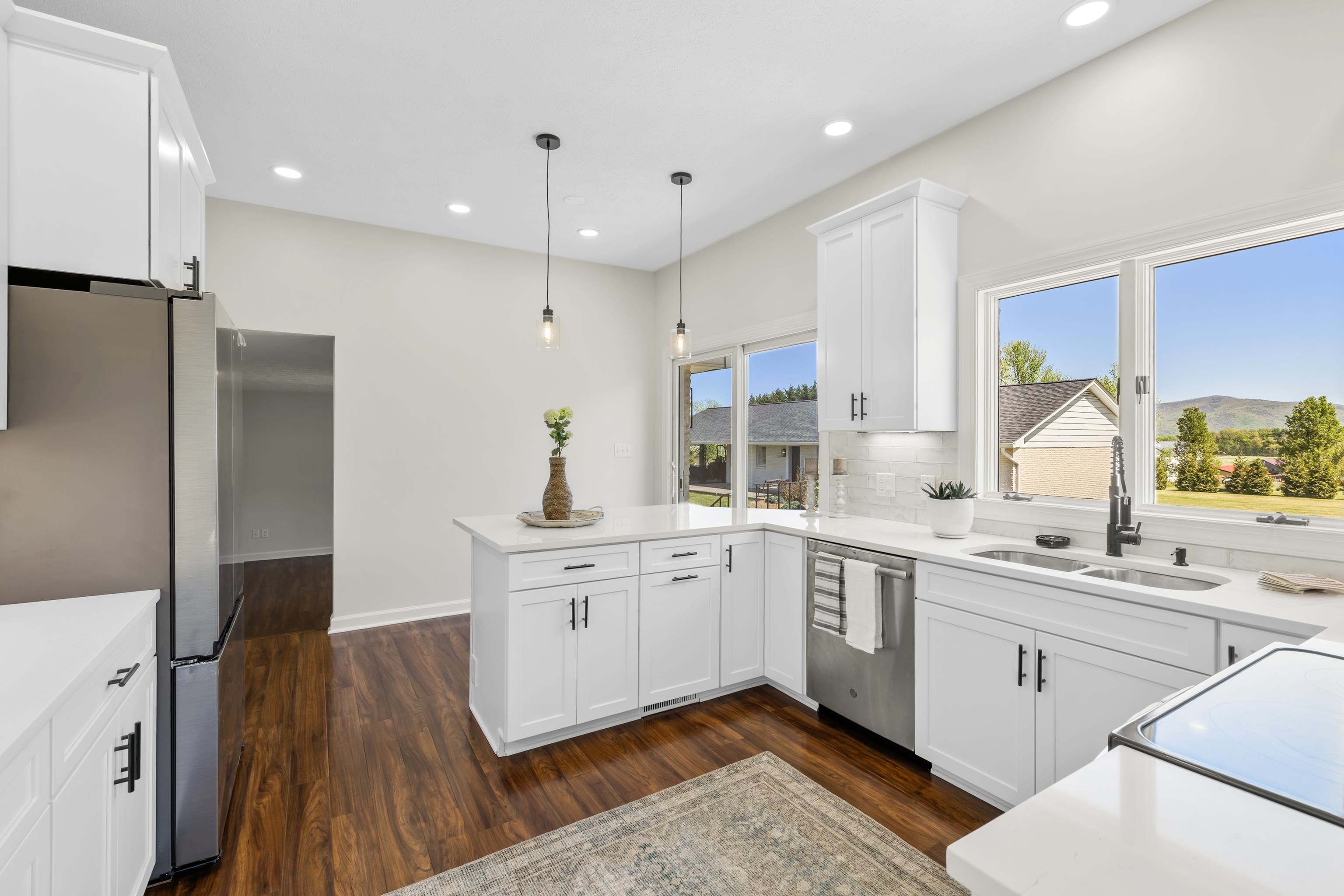 Simply gorgeous! The space is bright and airy and offers pretty views. The cabinets, quartz counter-tops, tile backsplash, refrigerator, and light fixtures are all brand new.