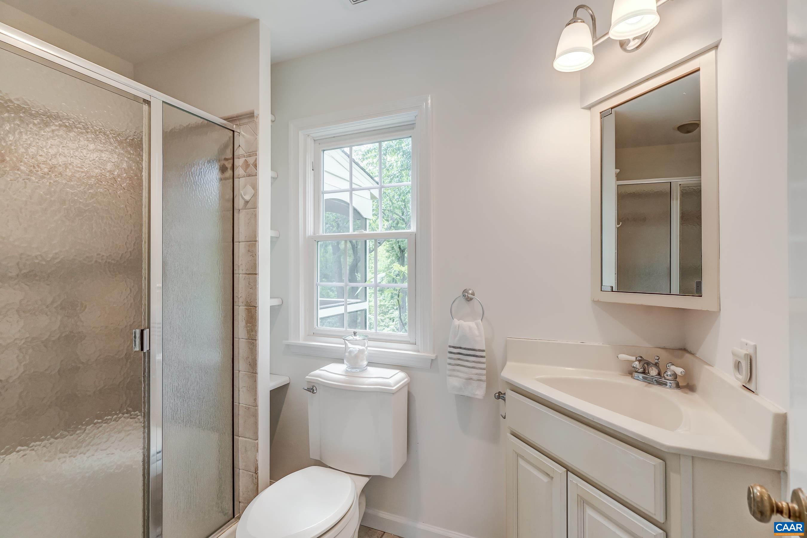 Primary bathroom with shower and corner sink.