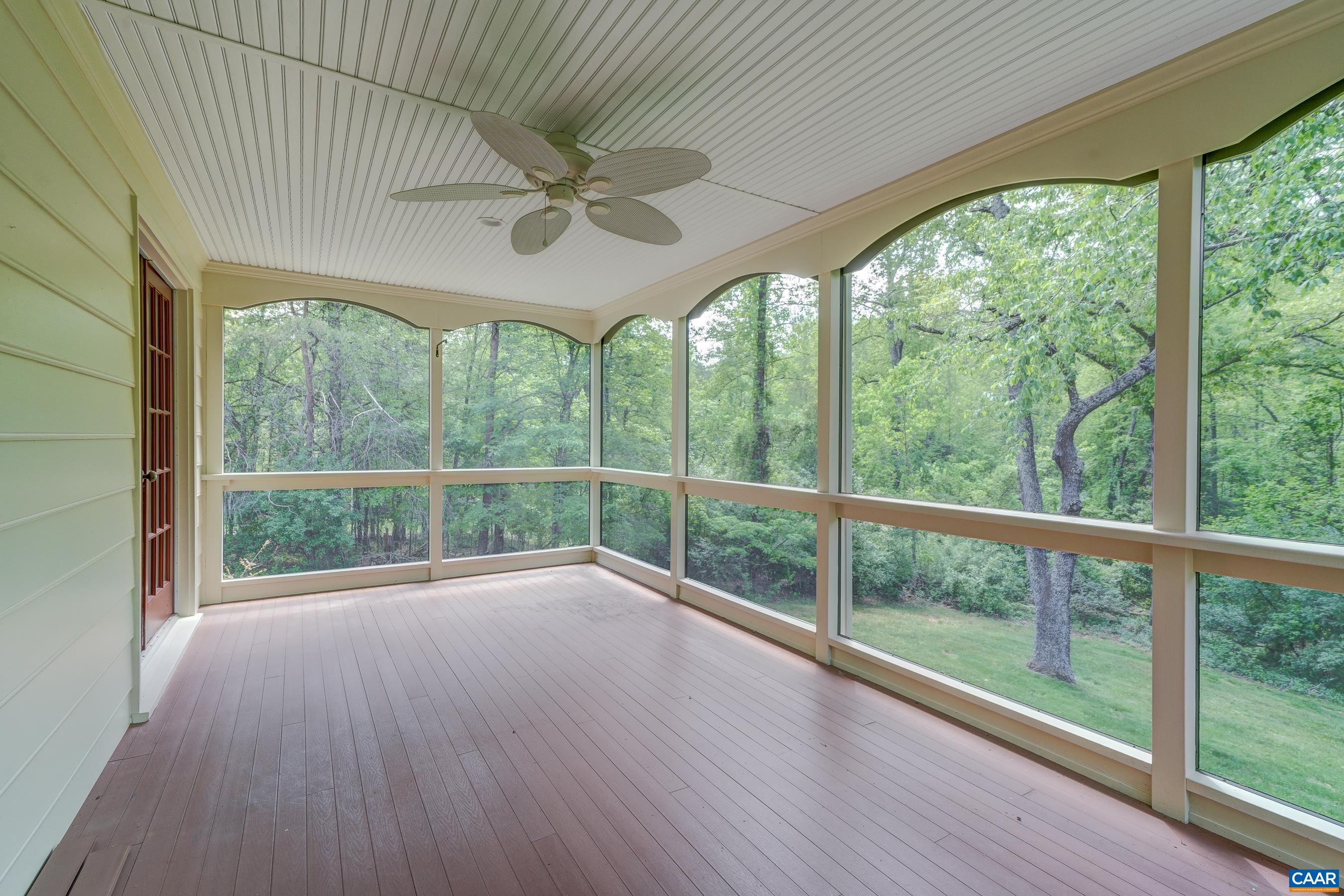 Screened porch features ceiling fan and roller shades to keep cool.