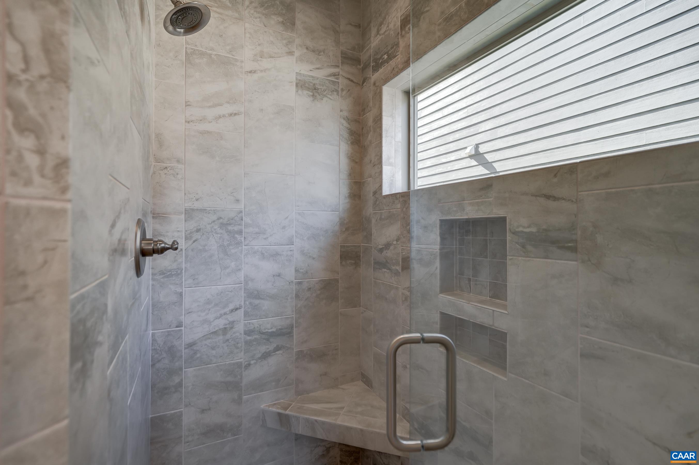 Tile walk-in shower in primary bathroom.