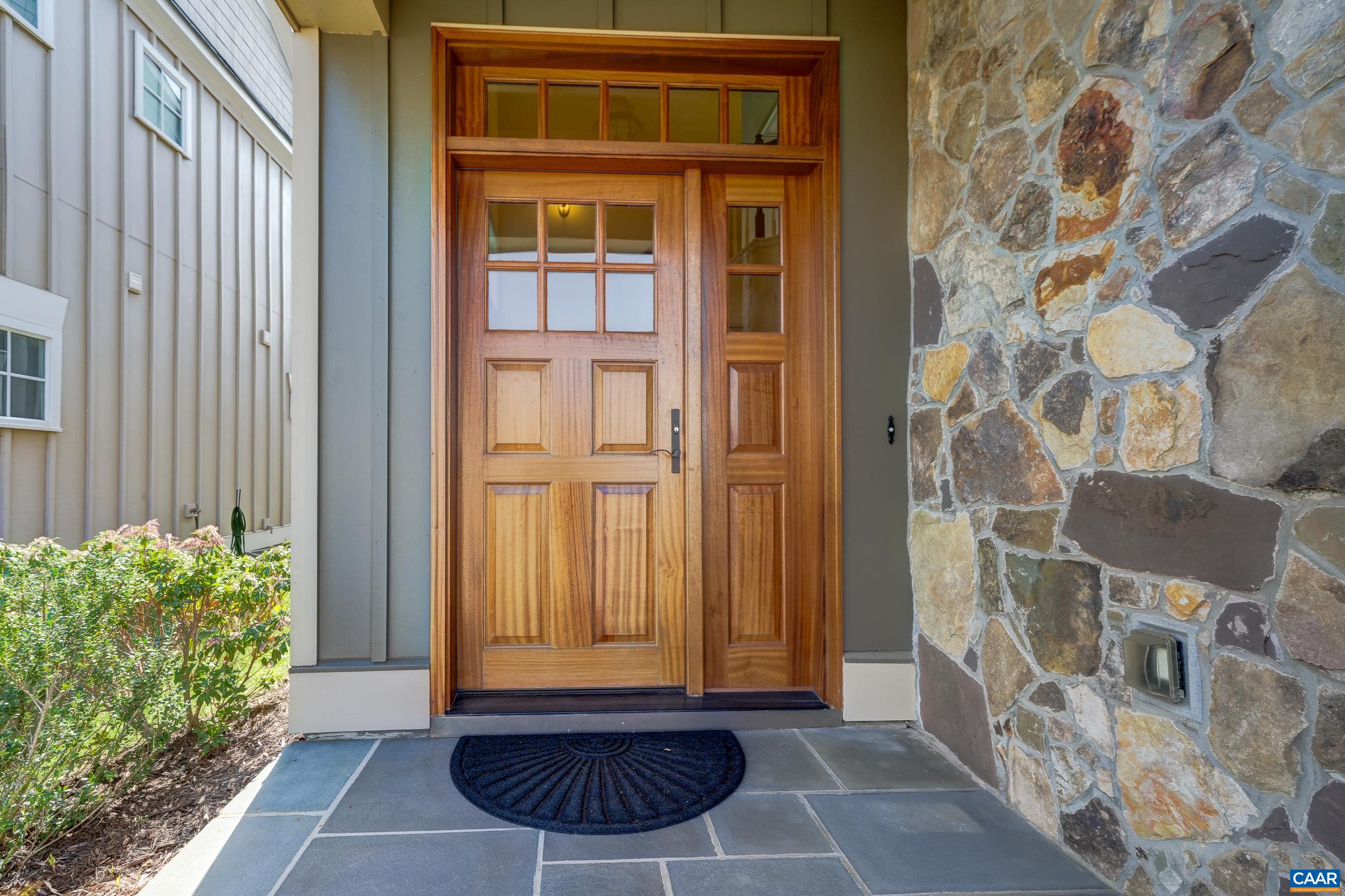 Bluestone covered front porch and solid wood front door with side light and transom welcome you home.