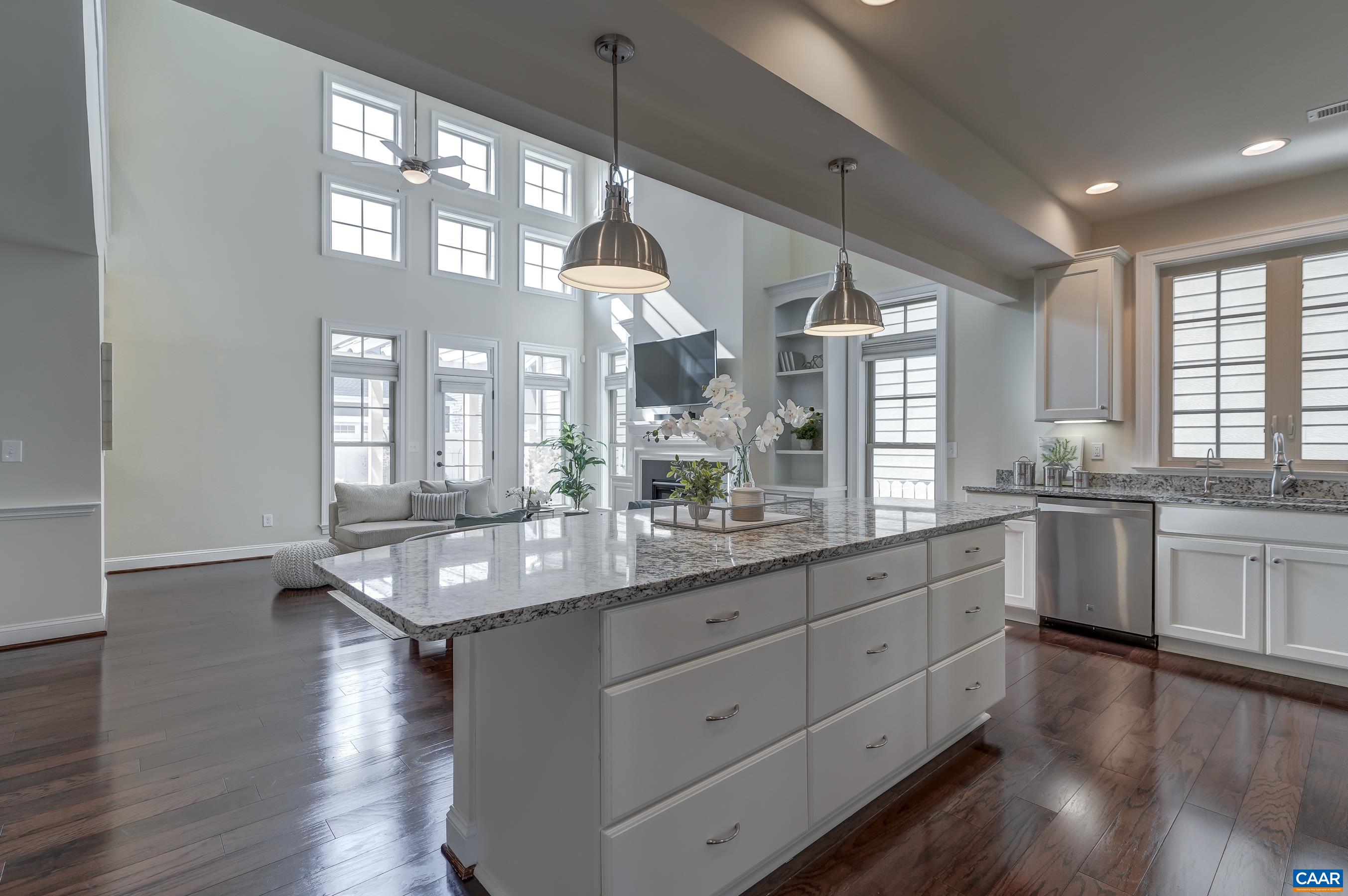 Gourmet kitchen with white cabinets and granite counterops opens to the soaring great room.