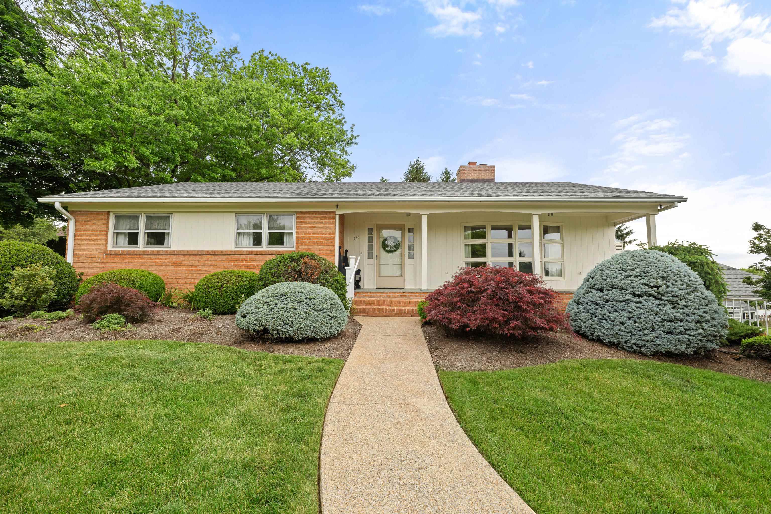 *Brick exterior with some wood, mature landscape.