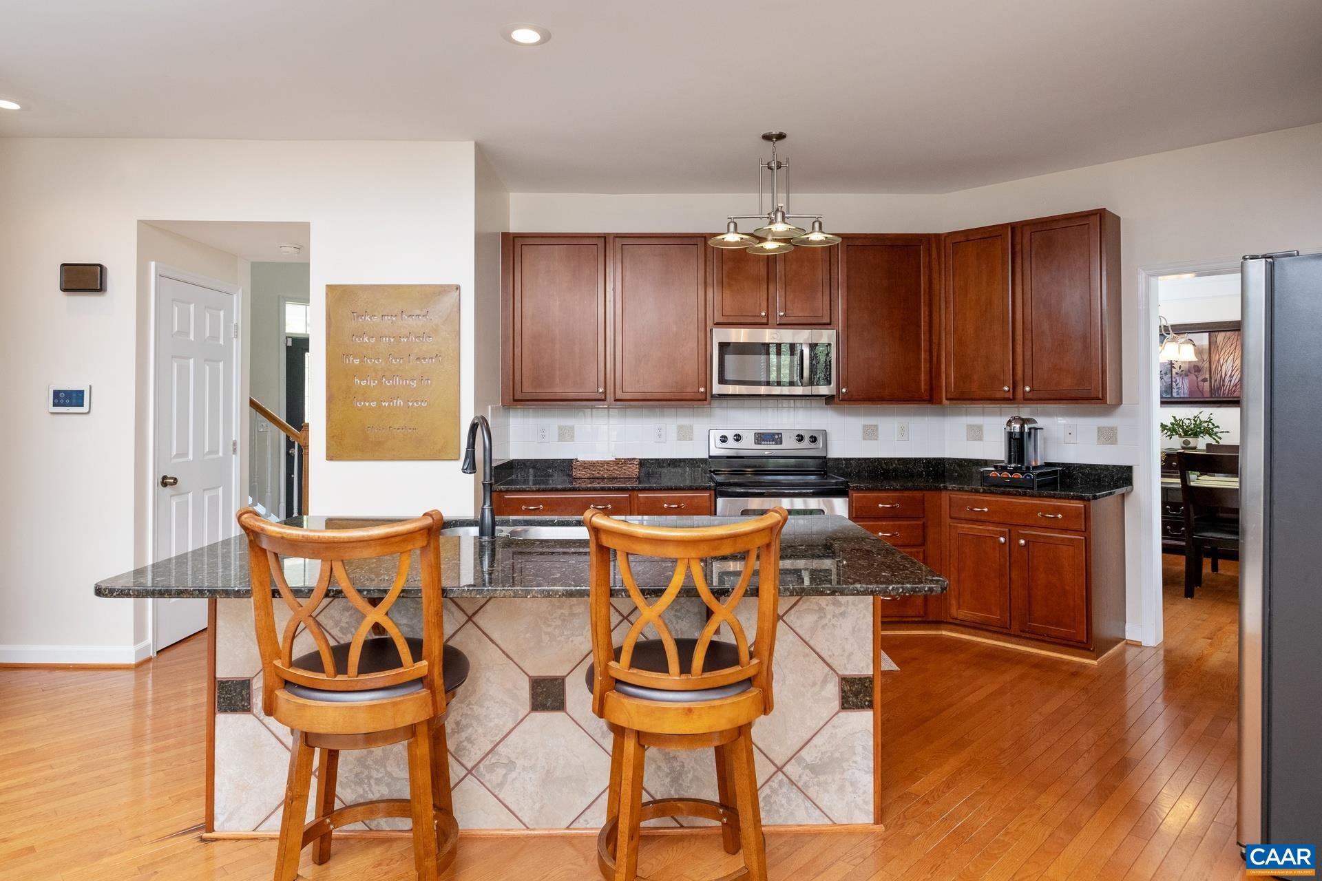 Kitchen features island, cherry cabinetry, and granite counter tops.