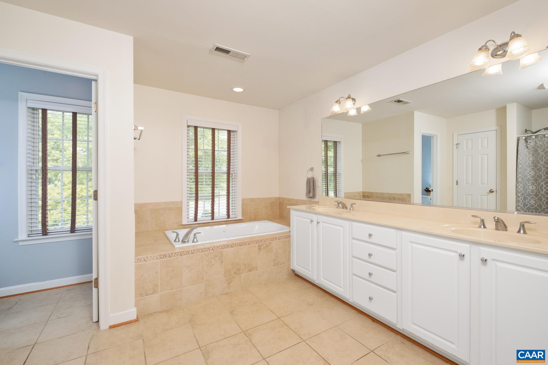 Primary bathroom features jetted tub, double vanities, water closet, and shower stall.