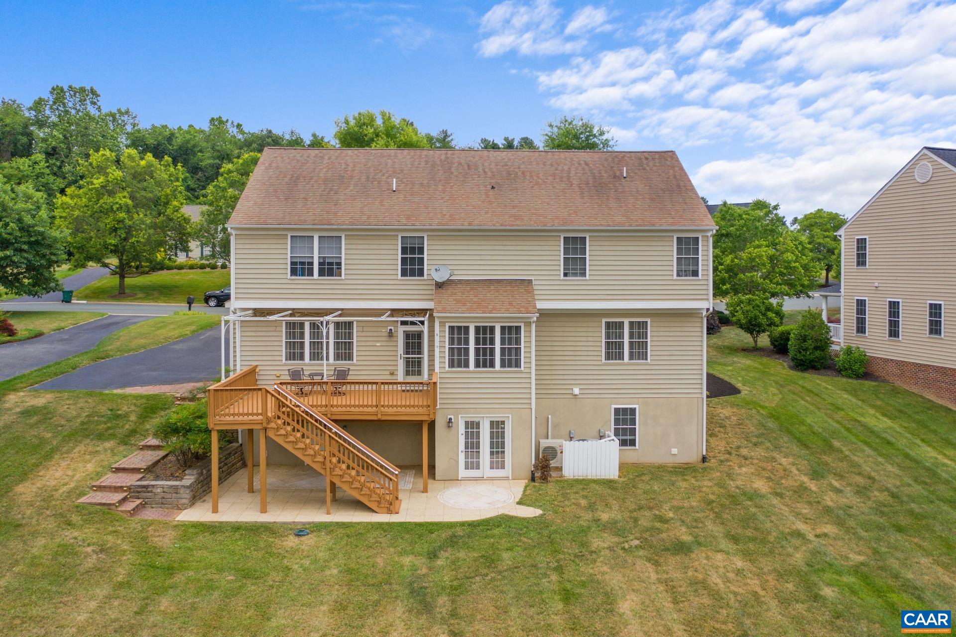 The back of the property with walkout basement in view, along with the back deck, and beautiful mountain views.