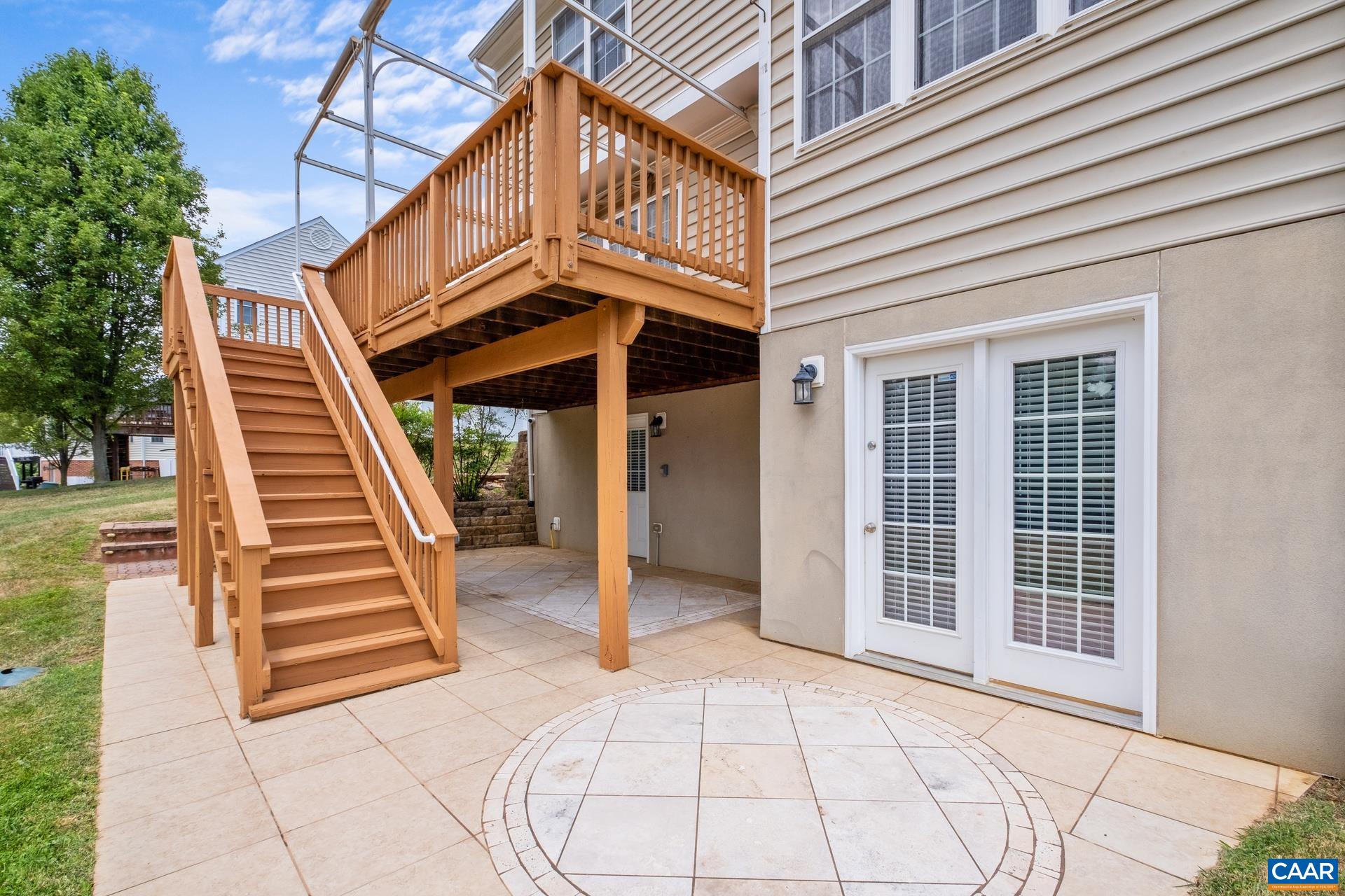 Back deck with stairs to the custom tile patio area.
