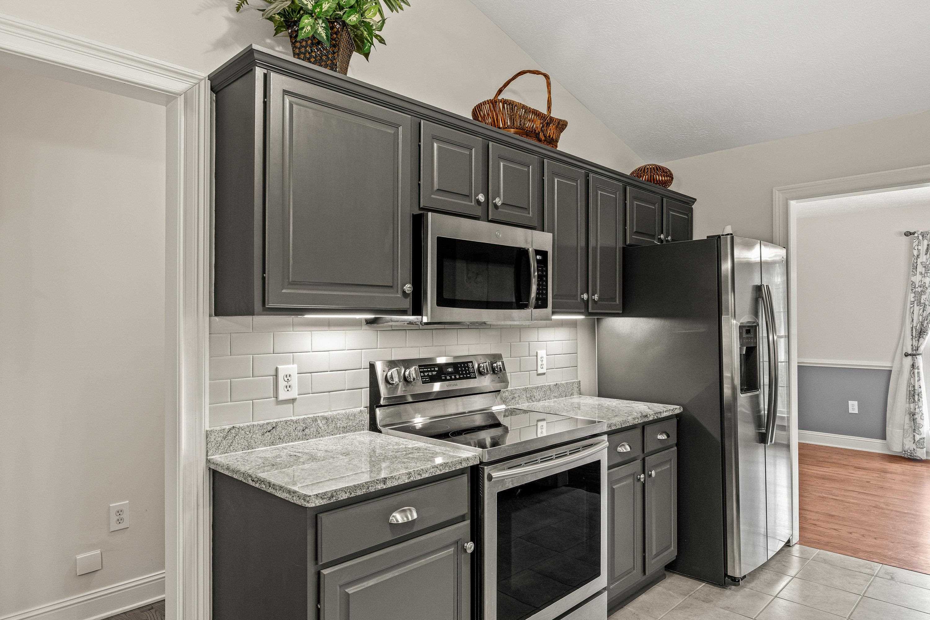 The updated kitchen contains new cabinetry, granite counter-tops, ceramic tile flooring, under cabinet lighting, and stainless steel appliances!