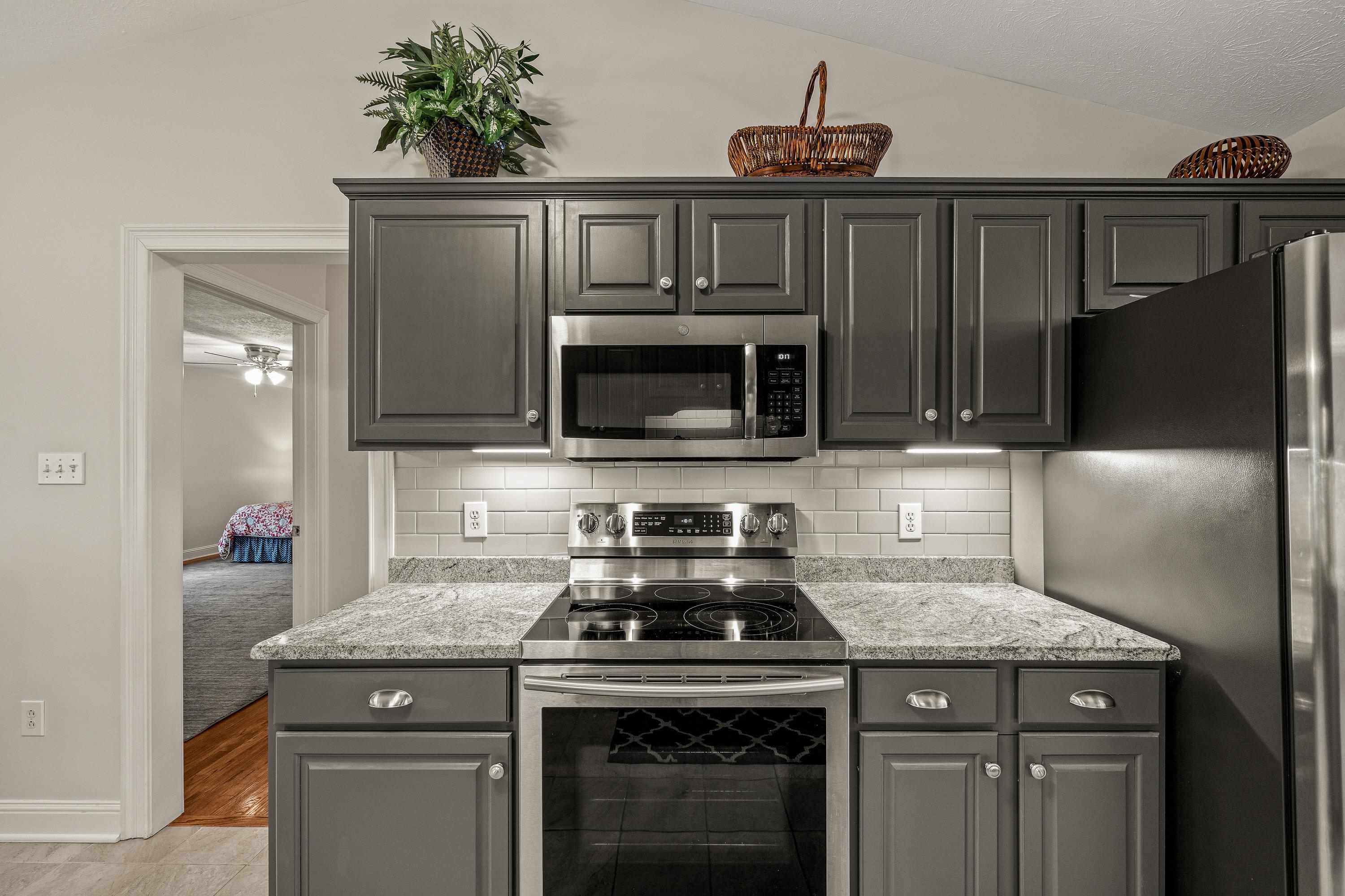 The updated kitchen contains new cabinetry, granite counter-tops, ceramic tile flooring, under cabinet lighting, and stainless steel appliances!