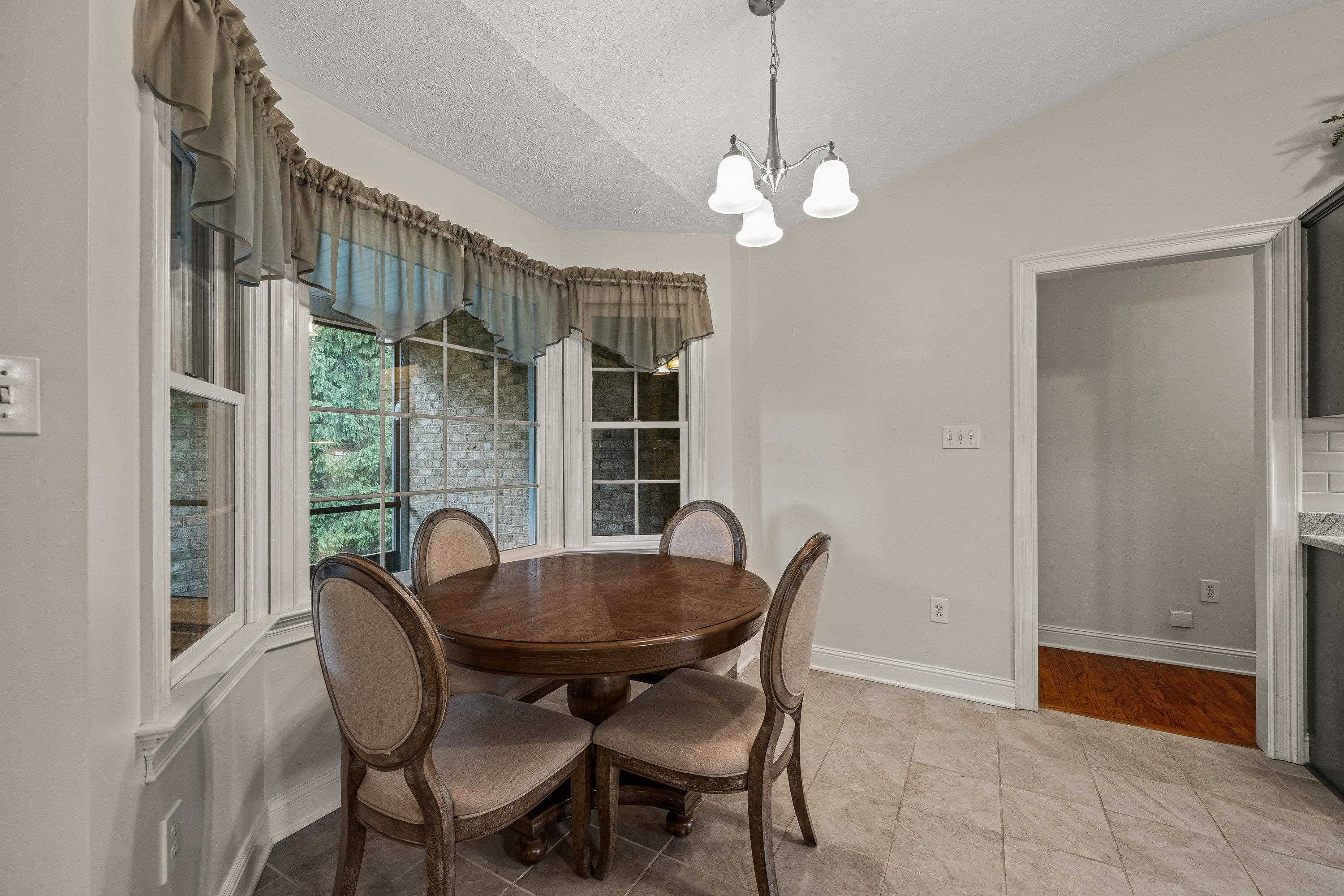 The open dining area features a bay window, updated light fixture, and is conveniently located directly off the kitchen.