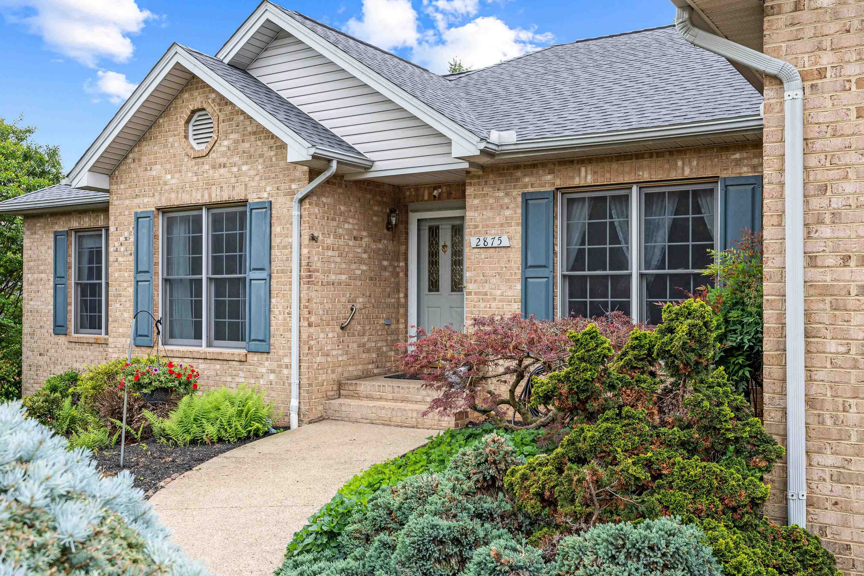 The front view of the beautiful home located at 2875 Barrington Drive in the lovely and established neighborhood of Barrington Estates.  The front view highlights the brick exterior of the home, two car garage, and mature landscaping surrounding the home!