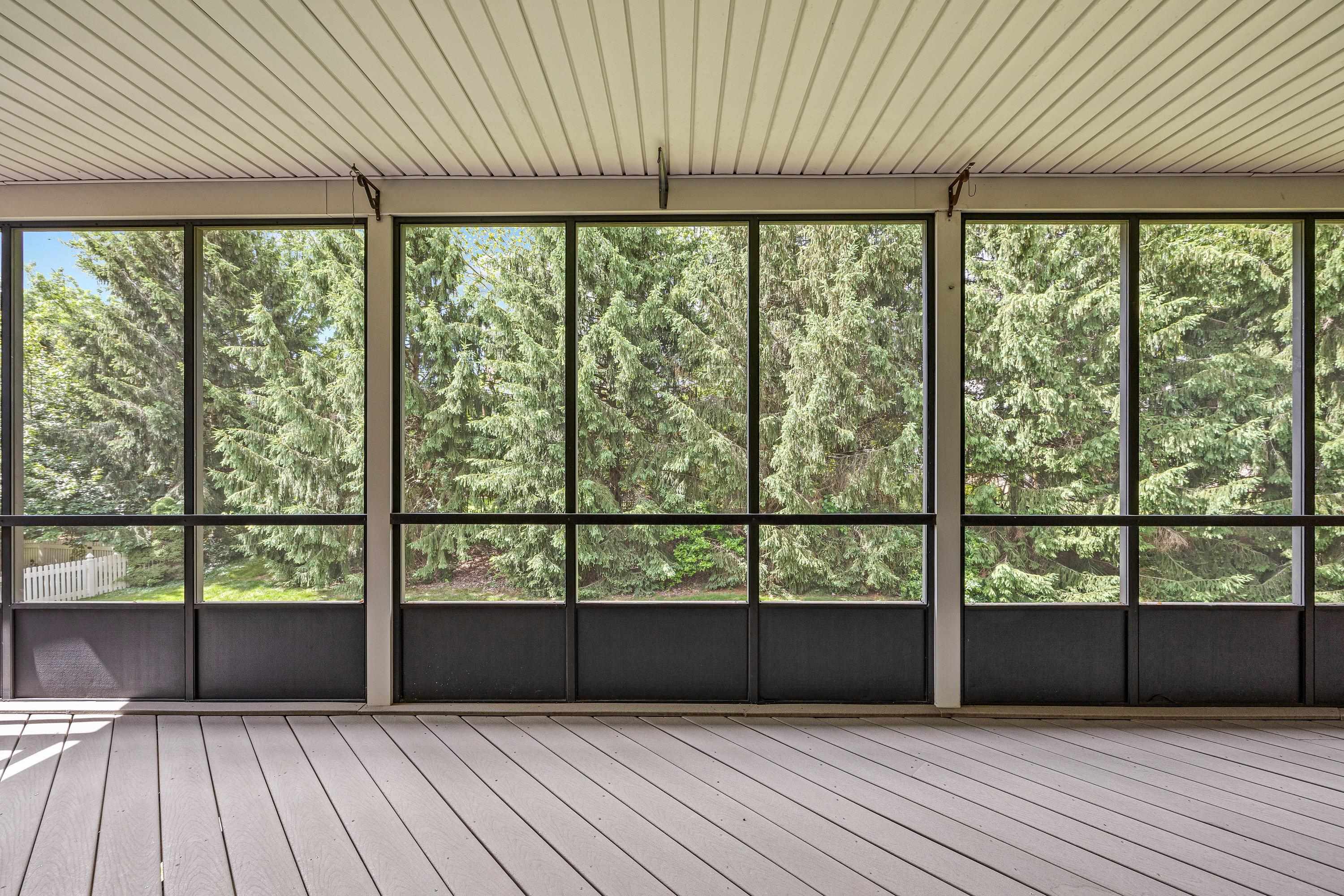 The large screened porch is located in the rear of the home and overlooks the beautiful backyard with mature trees and landscaping.