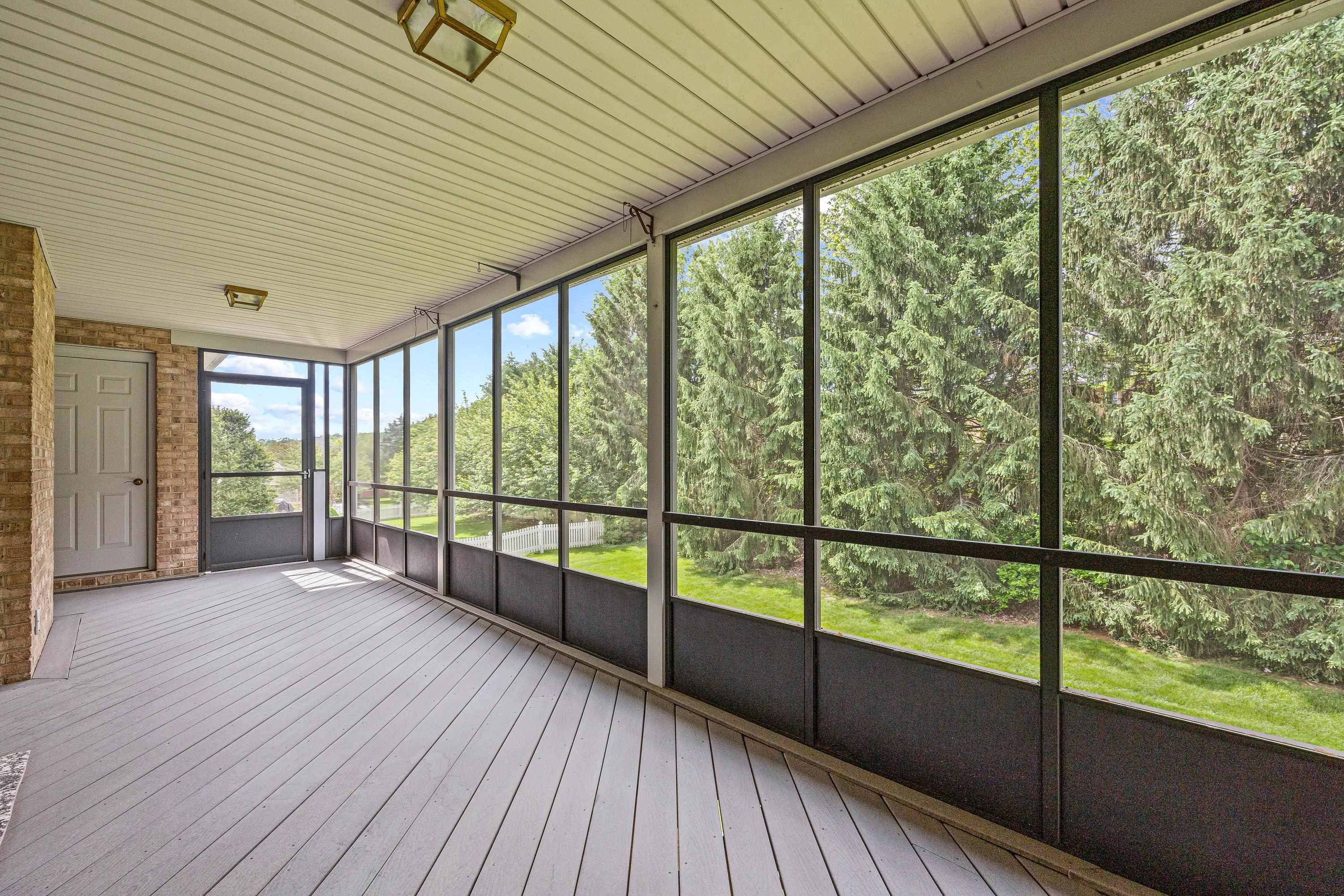 The large screened porch is located in the rear of the home and overlooks the beautiful backyard with mature trees and landscaping.
