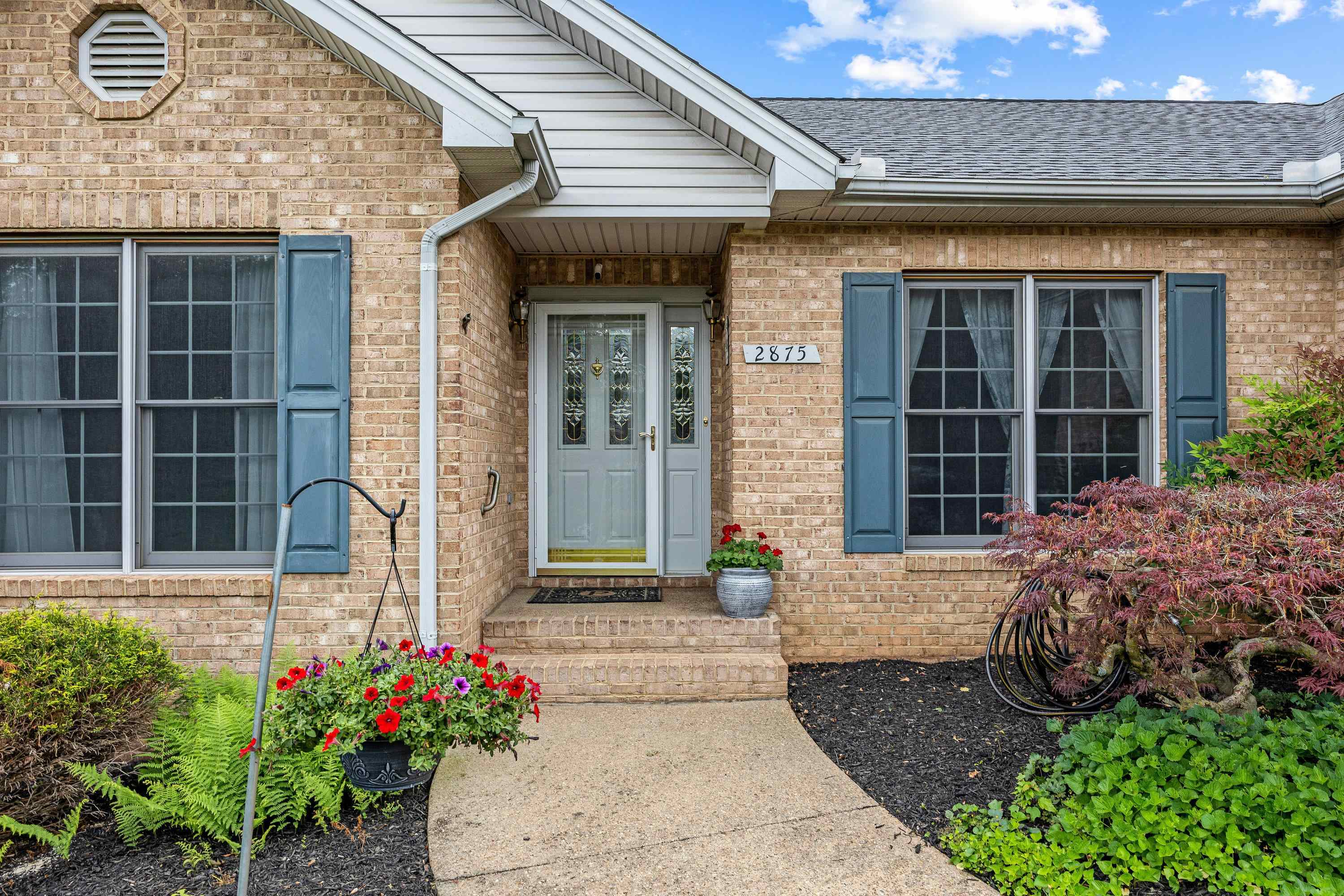 The front view of the beautiful home located at 2875 Barrington Drive in the lovely and established neighborhood of Barrington Estates.  The front view highlights the brick exterior of the home, two car garage, and mature landscaping surrounding the home!