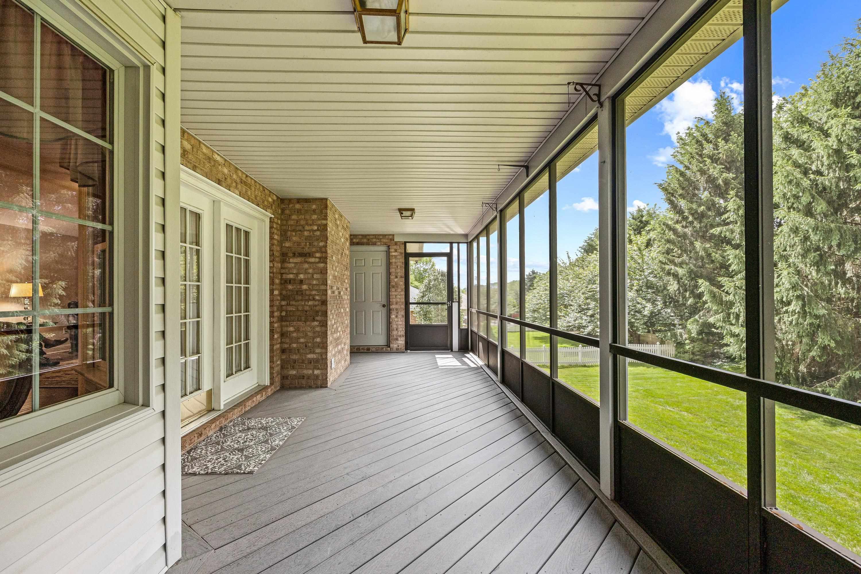 The large screened porch is located in the rear of the home and overlooks the beautiful backyard with mature trees and landscaping.