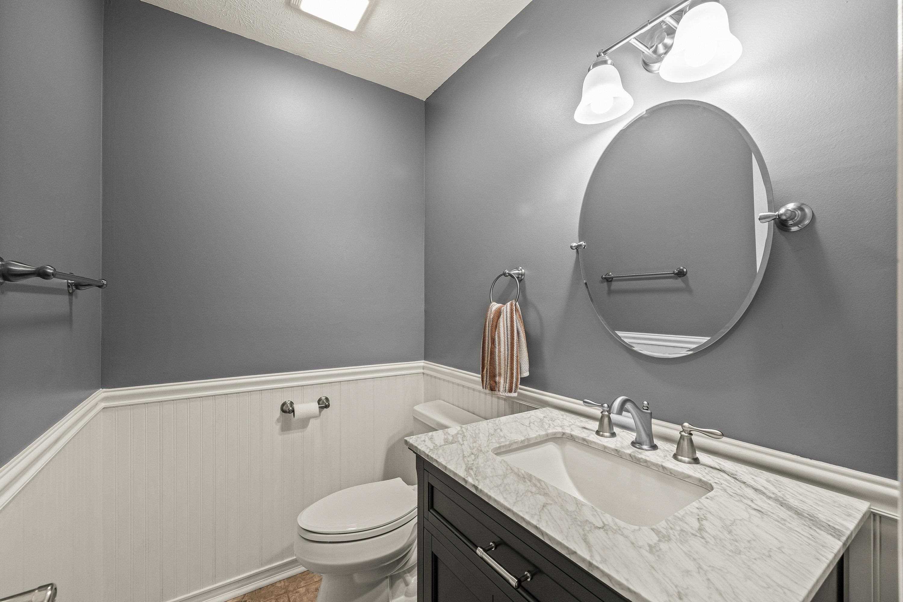 Located on the main level, this powder bathroom features a vanity with storage cabinetry.