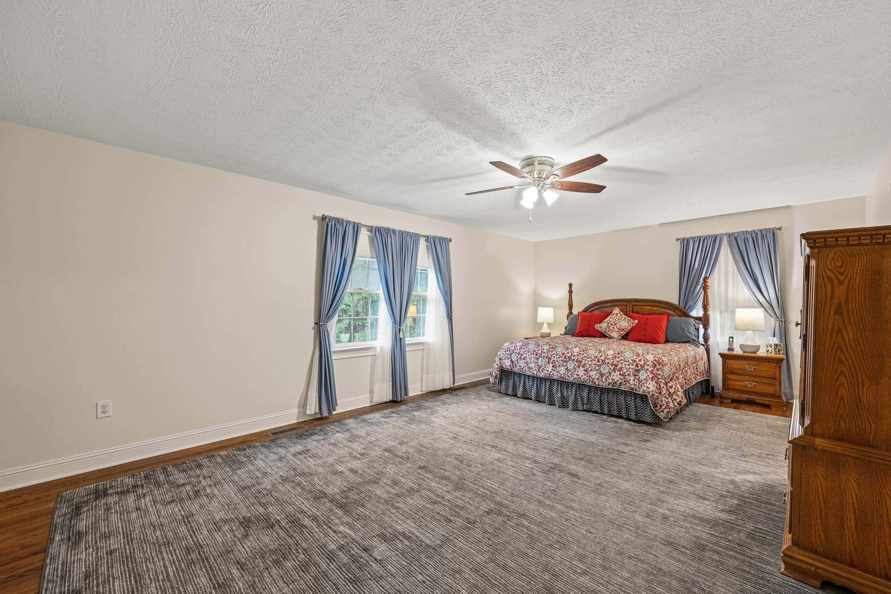 This incredibly large primary bedroom offers multiple windows, hardwood flooring throughout, ceiling fan, spacious attached bathroom, and walk-in closet for added convenience.