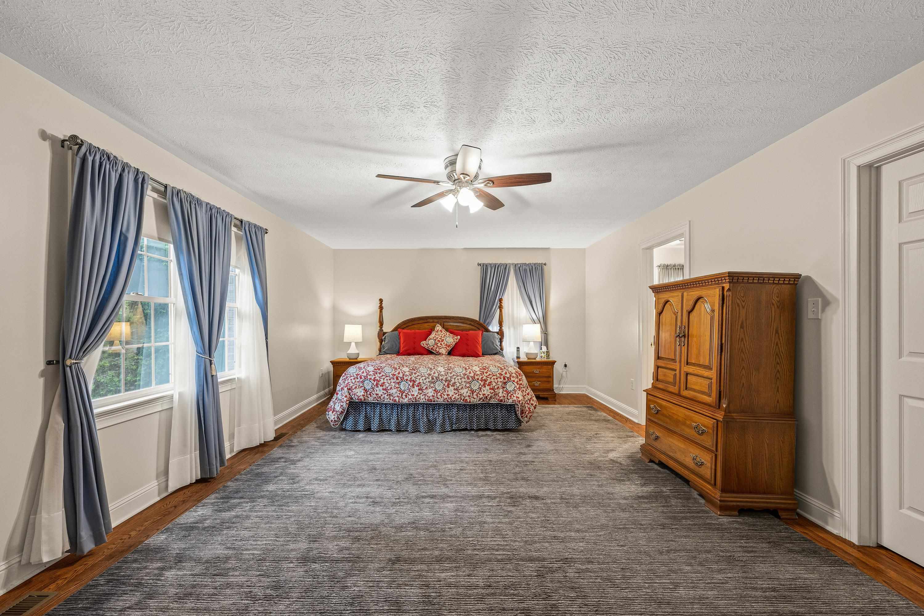 This incredibly large primary bedroom offers multiple windows, hardwood flooring throughout, ceiling fan, spacious attached bathroom, and walk-in closet for added convenience.