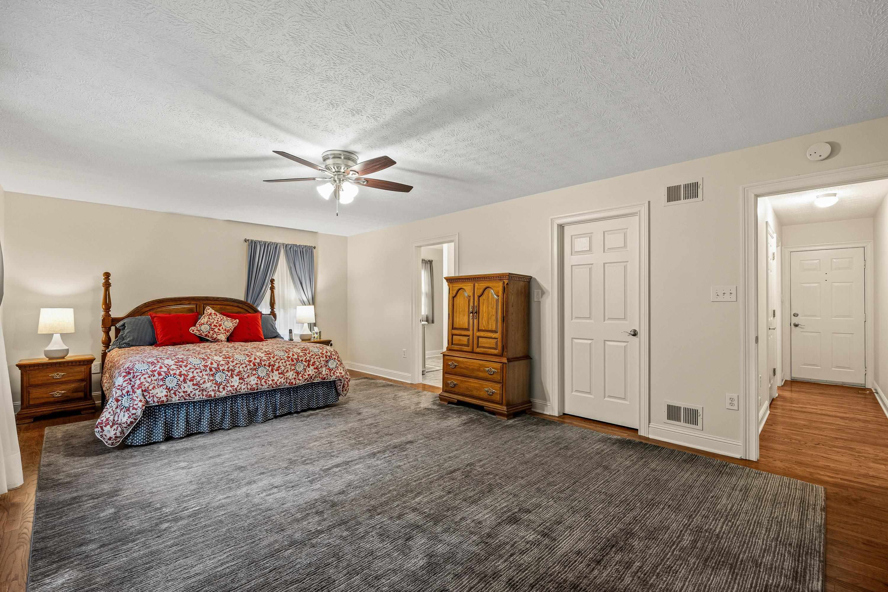 This incredibly large primary bedroom offers multiple windows, hardwood flooring throughout, ceiling fan, spacious attached bathroom, and walk-in closet for added convenience.