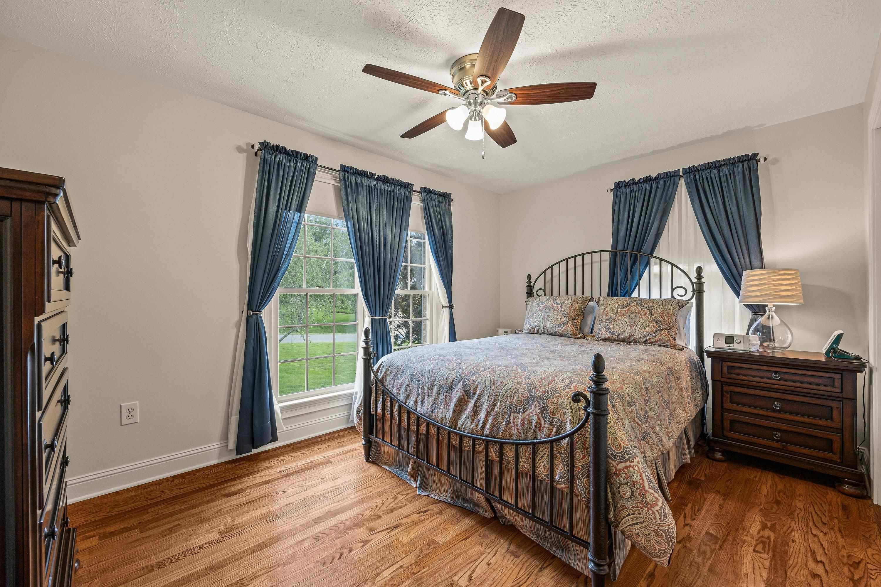 The second bedroom located on the main level offers a ceiling fan, hardwood flooring, and multiple windows allowing in an abundance of natural light!