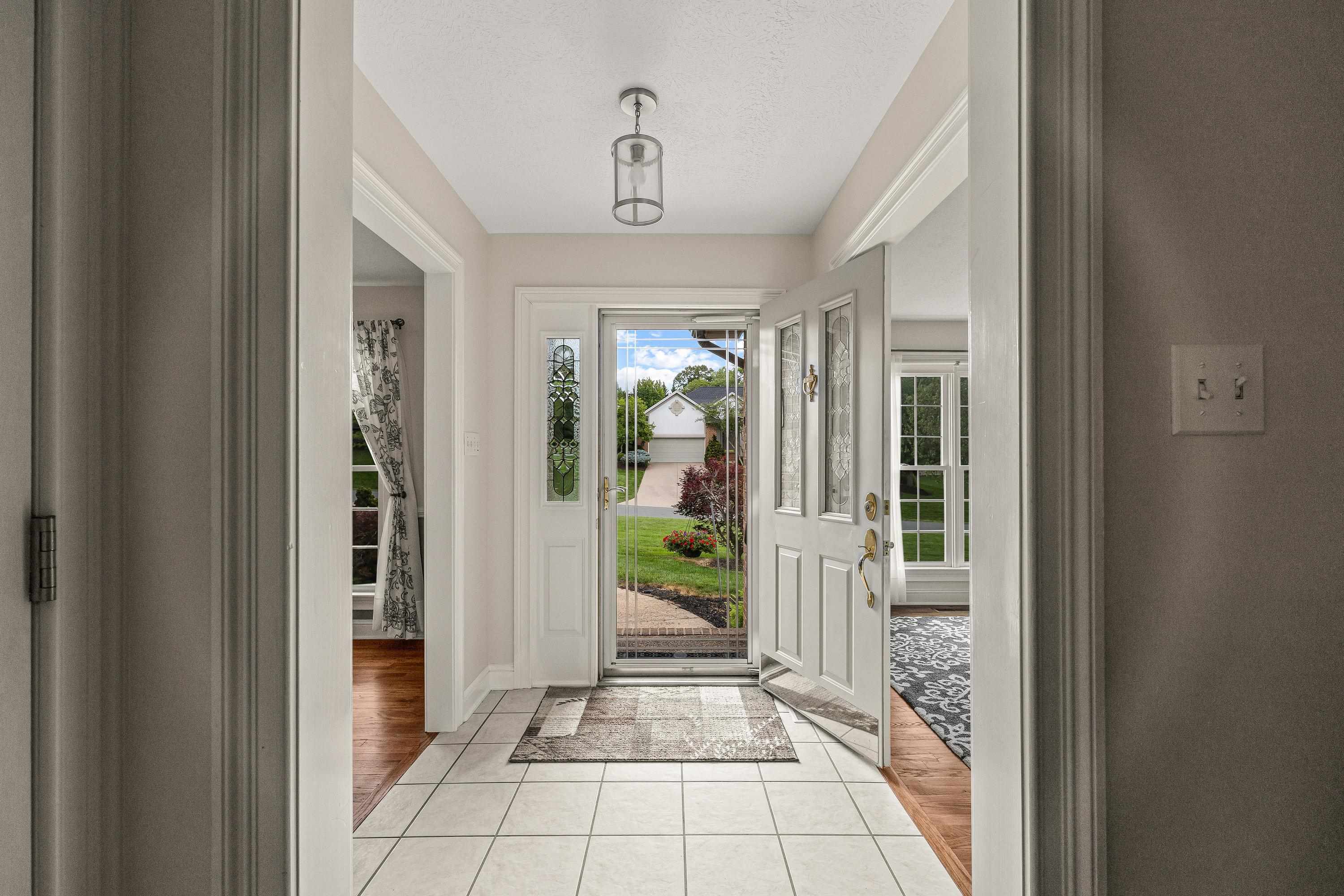 The front foyer space is open and full of light.  This space opens into the living room, kitchen, dining room, and home office area.
