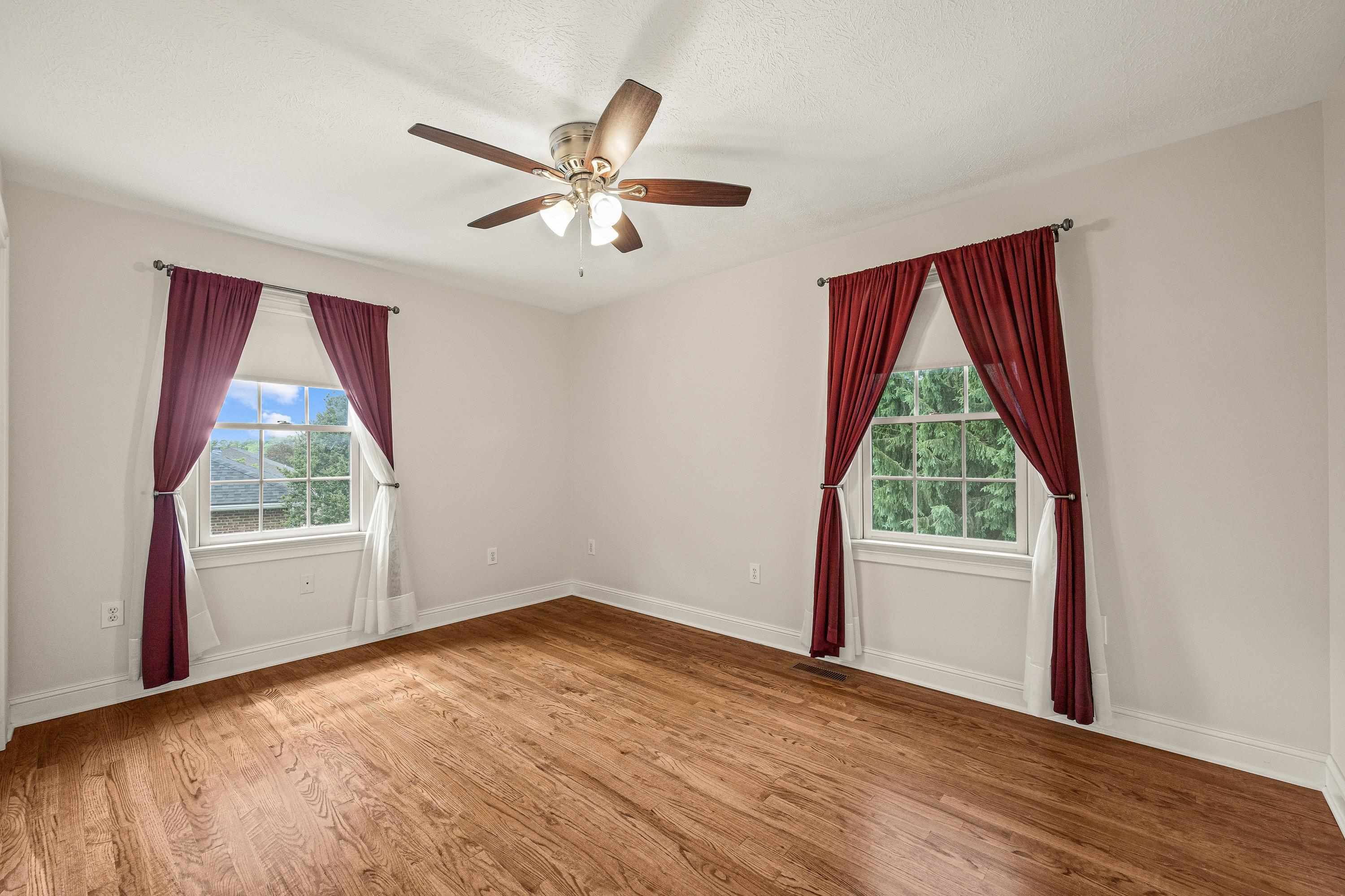 This third bedroom features hardwood flooring throughout, large windows, and a large closet space. All three bedrooms are located on the first floor of the home.