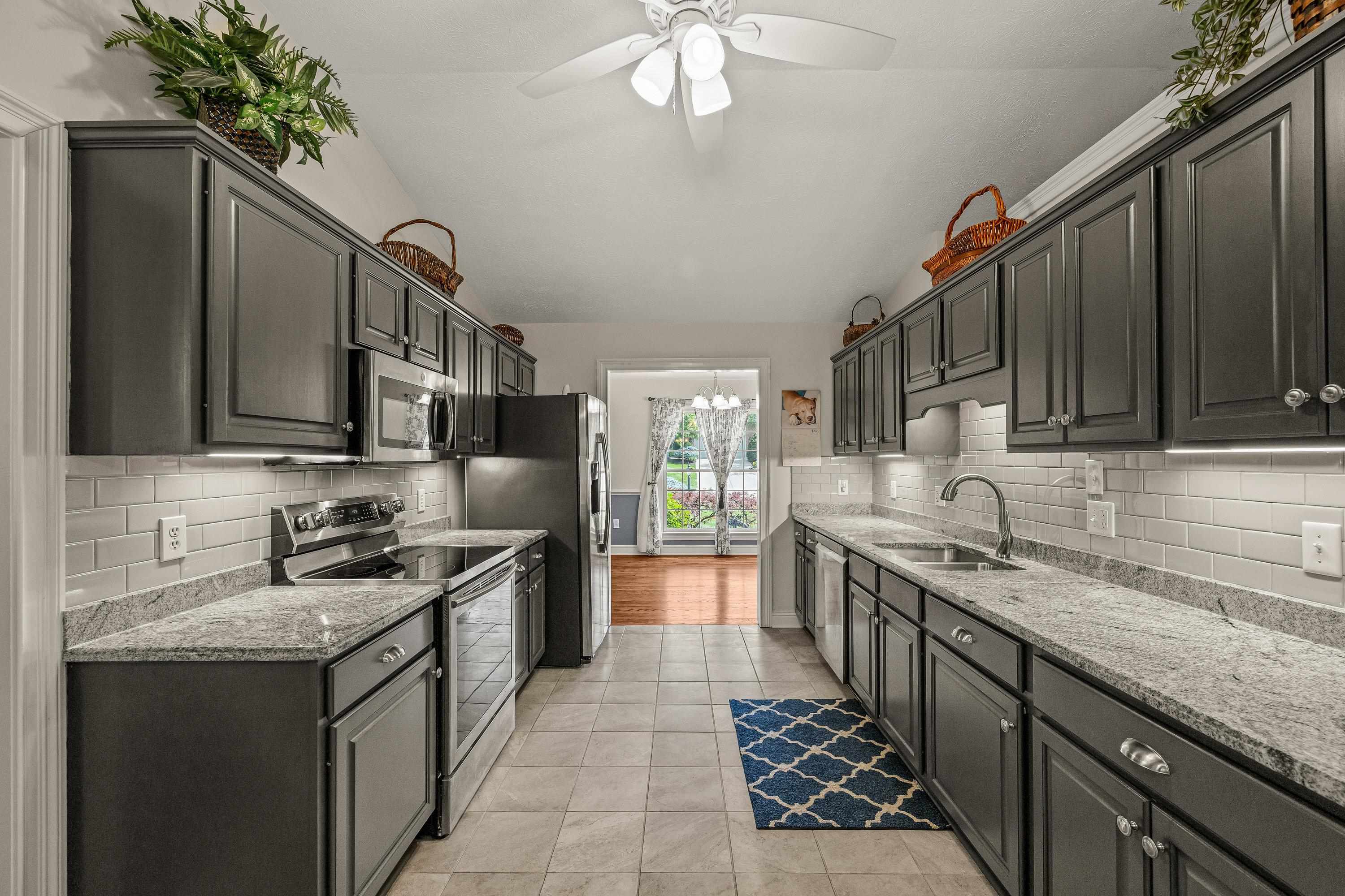 The updated kitchen contains new cabinetry, granite counter-tops, ceramic tile flooring, under cabinet lighting, and stainless steel appliances!