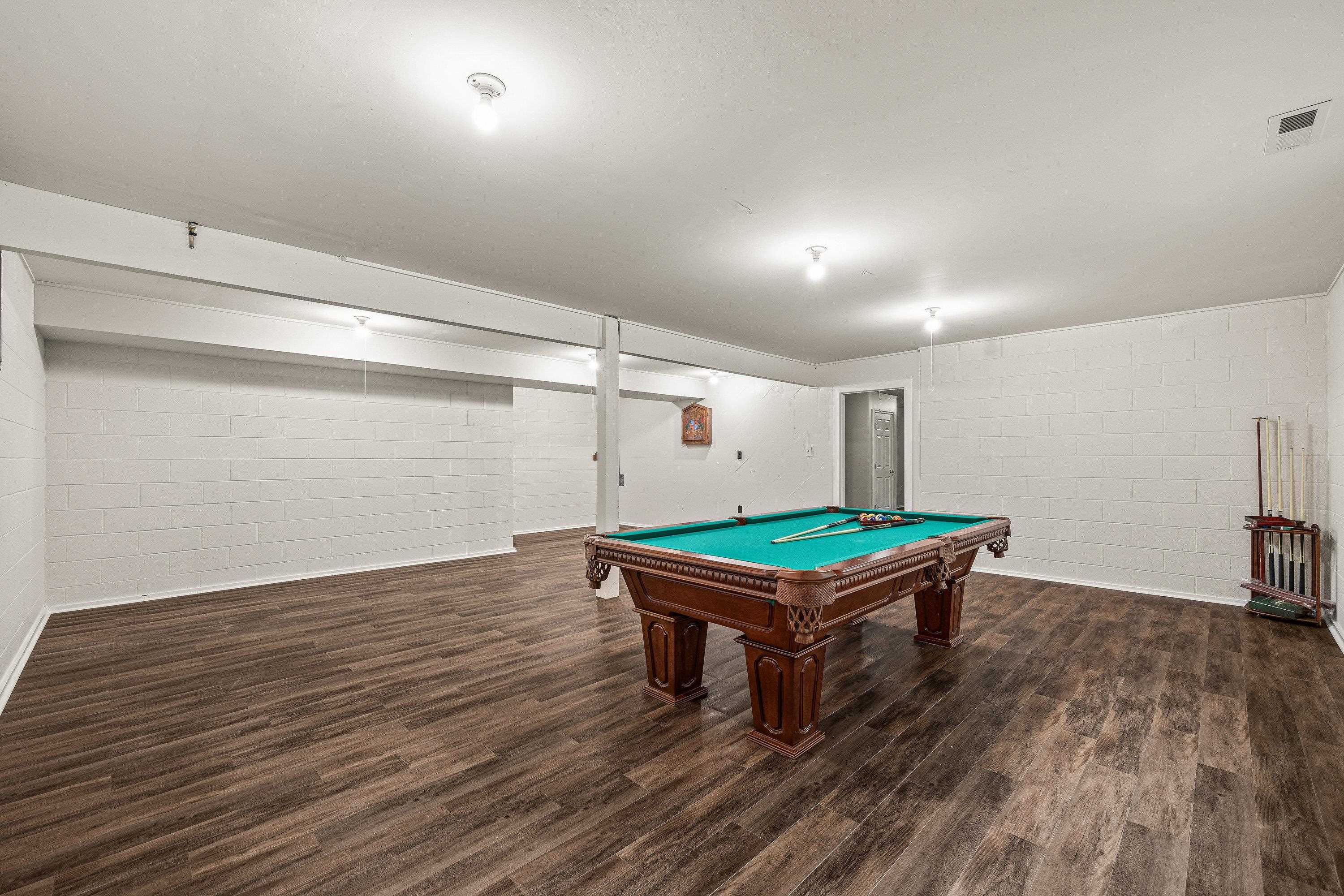 A billiard table in an added bonus in this very large game room.  This space offers luxury vinyl plank flooring, recessed lighting, and much more!