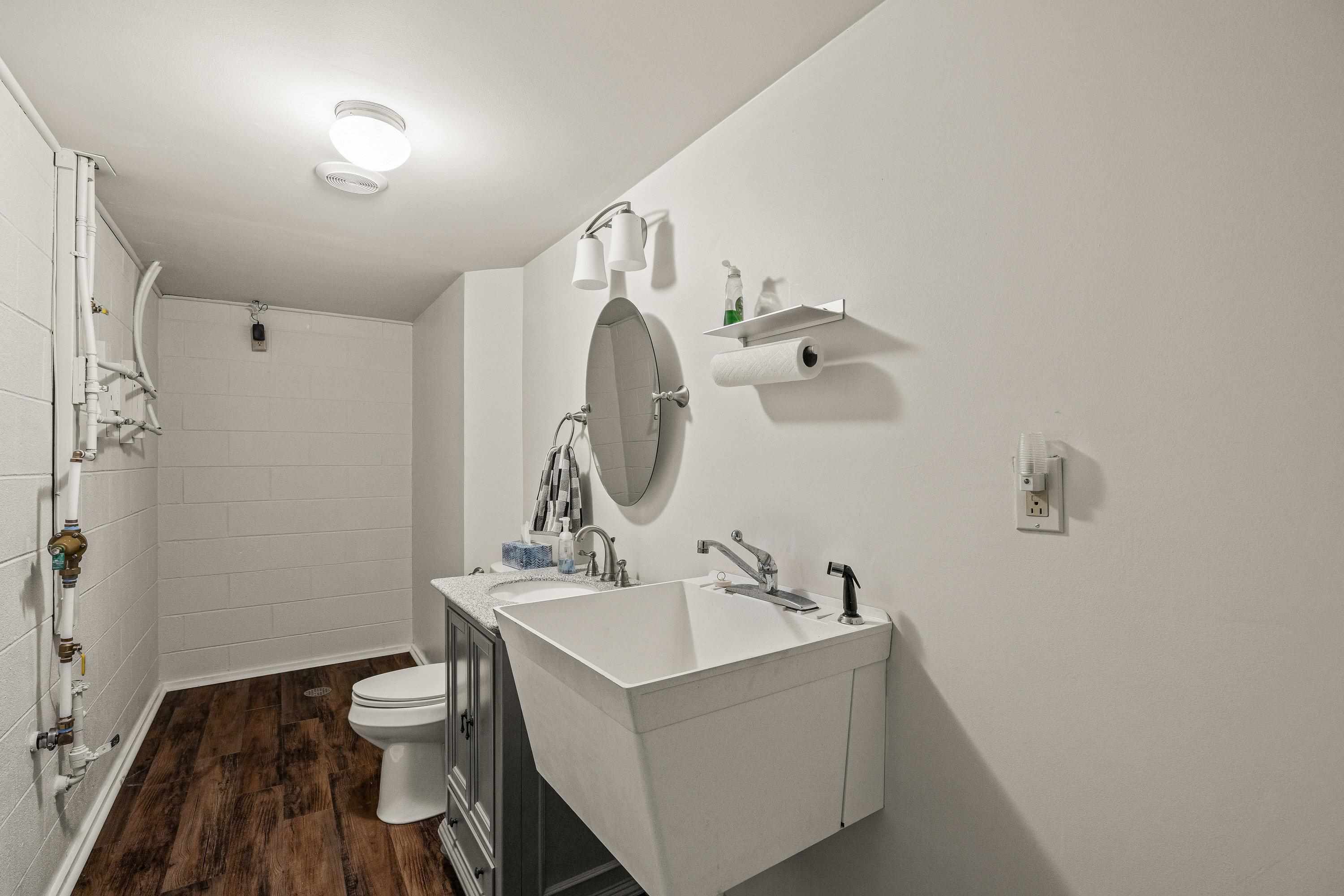 This basement bathroom features a utility sink and offers convenience to all the basement spaces.
