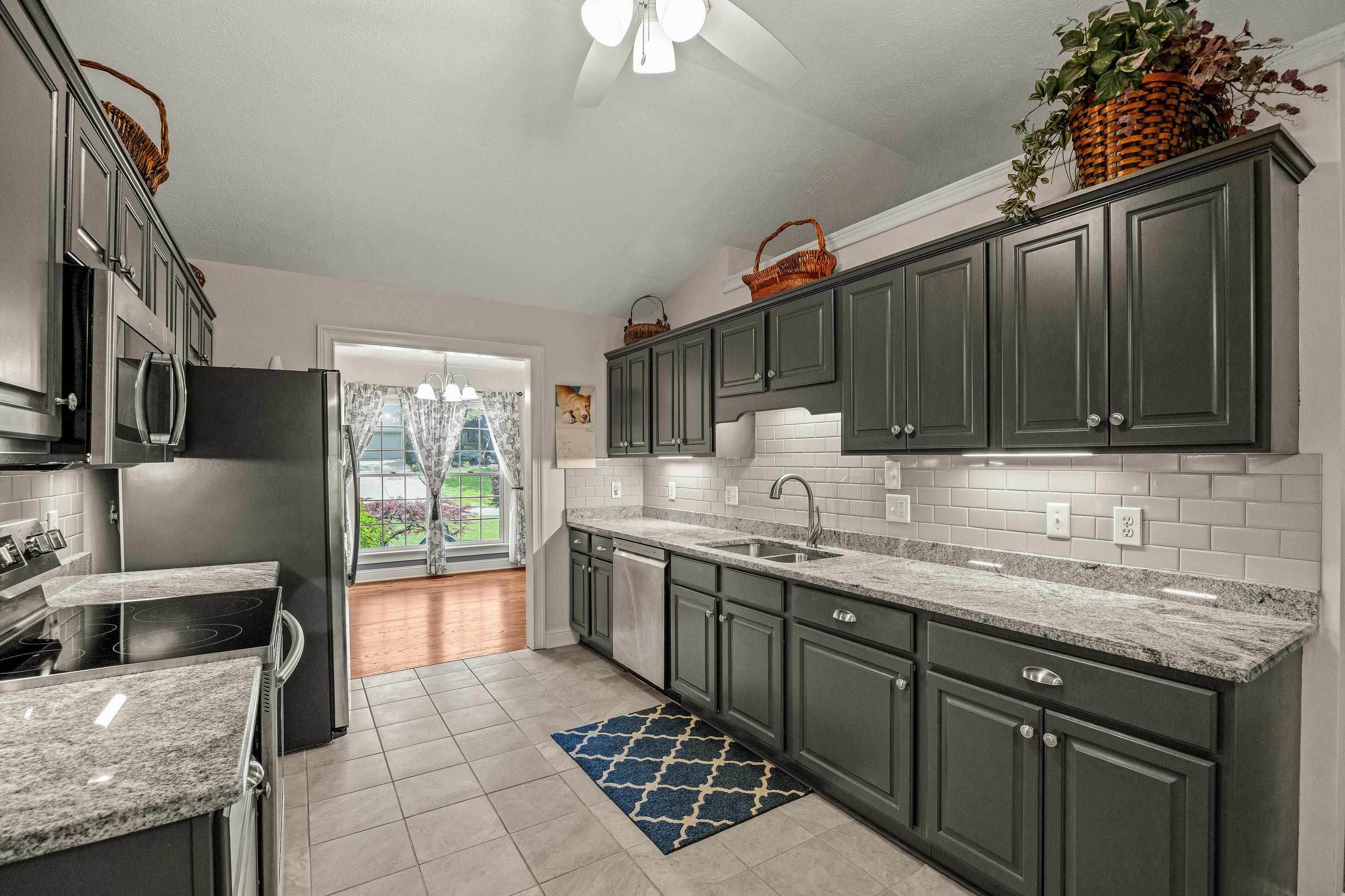 The updated kitchen contains new cabinetry, granite counter-tops, ceramic tile flooring, under cabinet lighting, and stainless steel appliances!