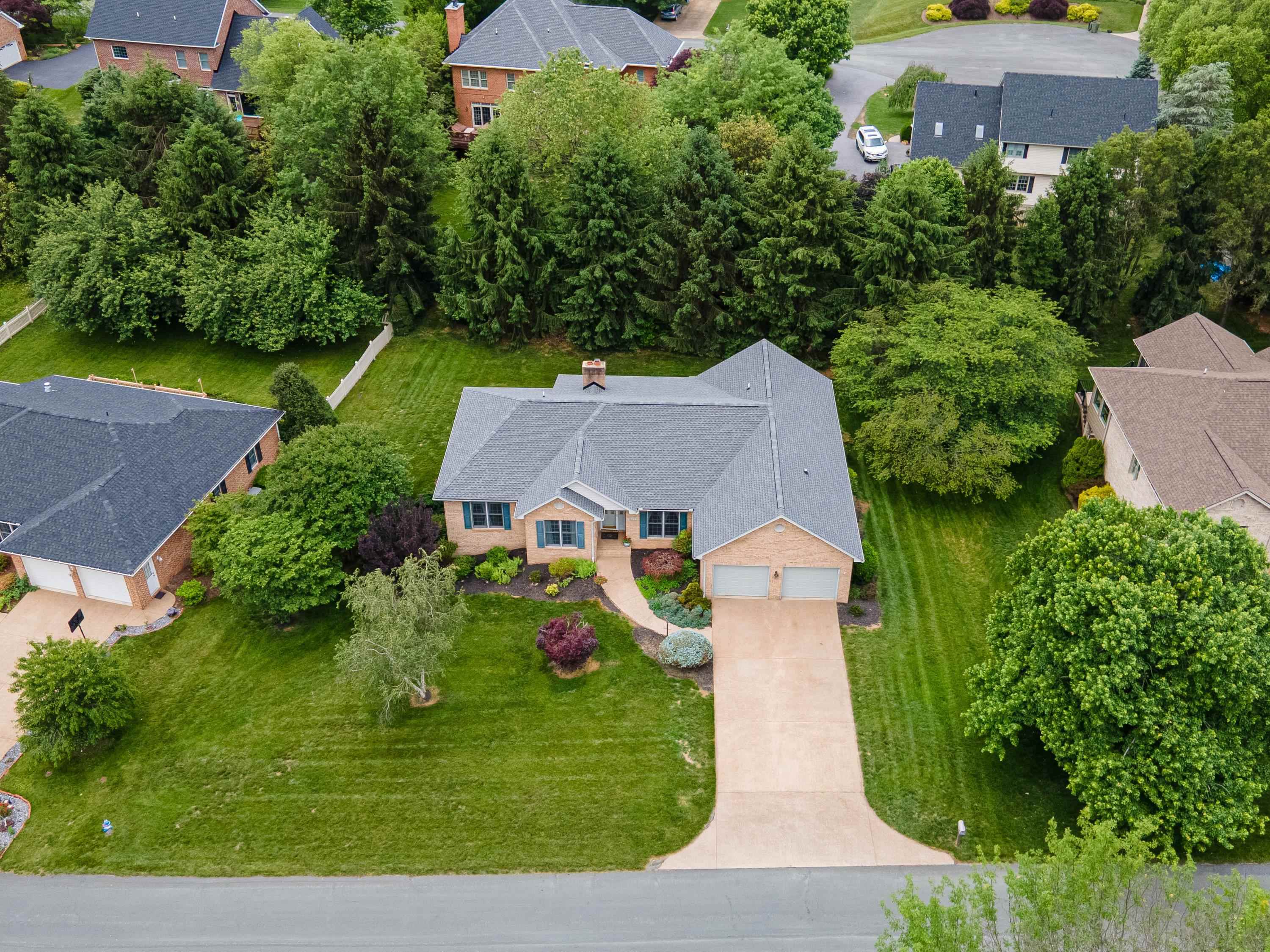 The aerial view highlights the spacious lot this home is located on, the mature landscaping surrounding the home, and the Barrington subdivision.