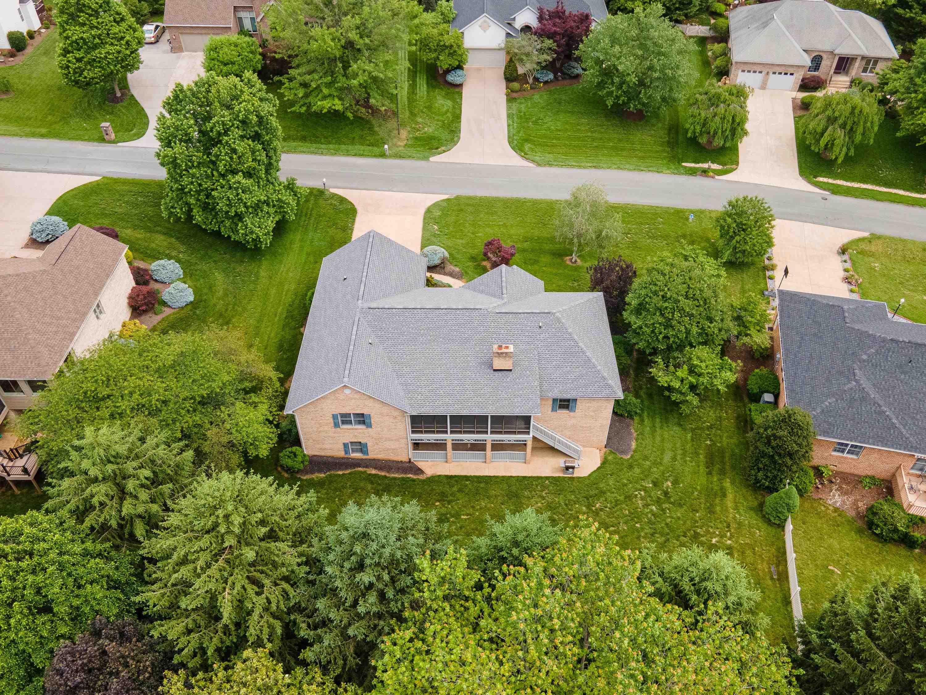 The aerial view highlights the spacious lot this home is located on, the mature landscaping surrounding the home, and the Barrington subdivision.